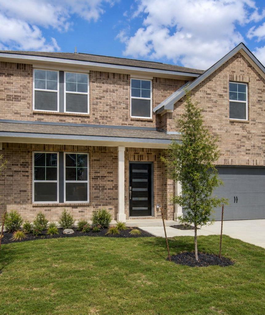 Spacious modern kitchen in Horizon Pointe Converse Texas with white shaker cabinets quartz island stainless appliances hardwood floors