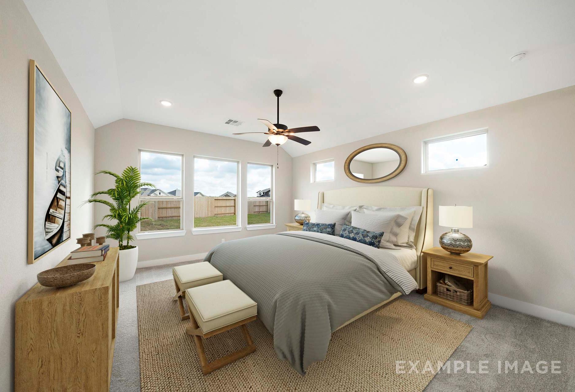 Spacious master suite in The Elizabeth A featuring plush gray king bed, ceiling fan, large windows, and neutral decor