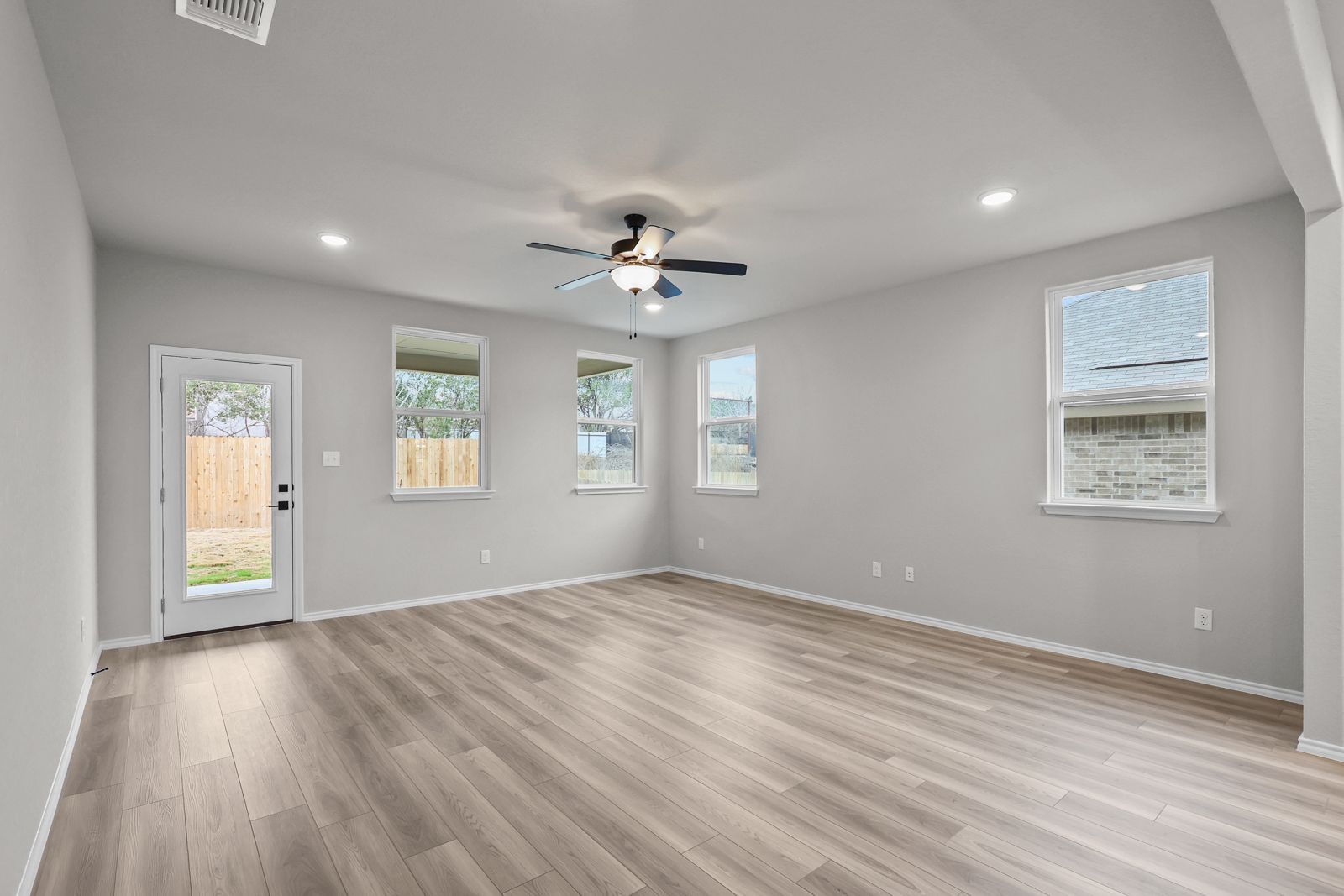 Spacious open-concept living area in The Glenwood E by Davidson Homes featuring light wood flooring and ceiling fan.
