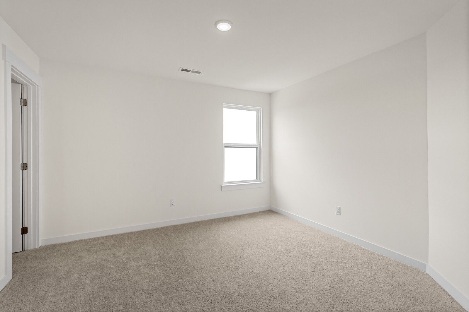 Bright empty bedroom with beige carpet, white walls, large window and open door in Davidson Homes Ridgeport D, Mt. Juliet