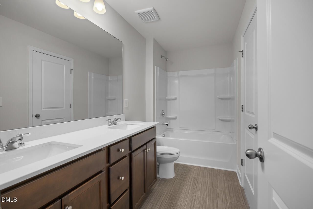 Elegant master bathroom with double vanity, soaking tub, and neutral tones in Davidson Homes The Gavin B, Lillington, NC