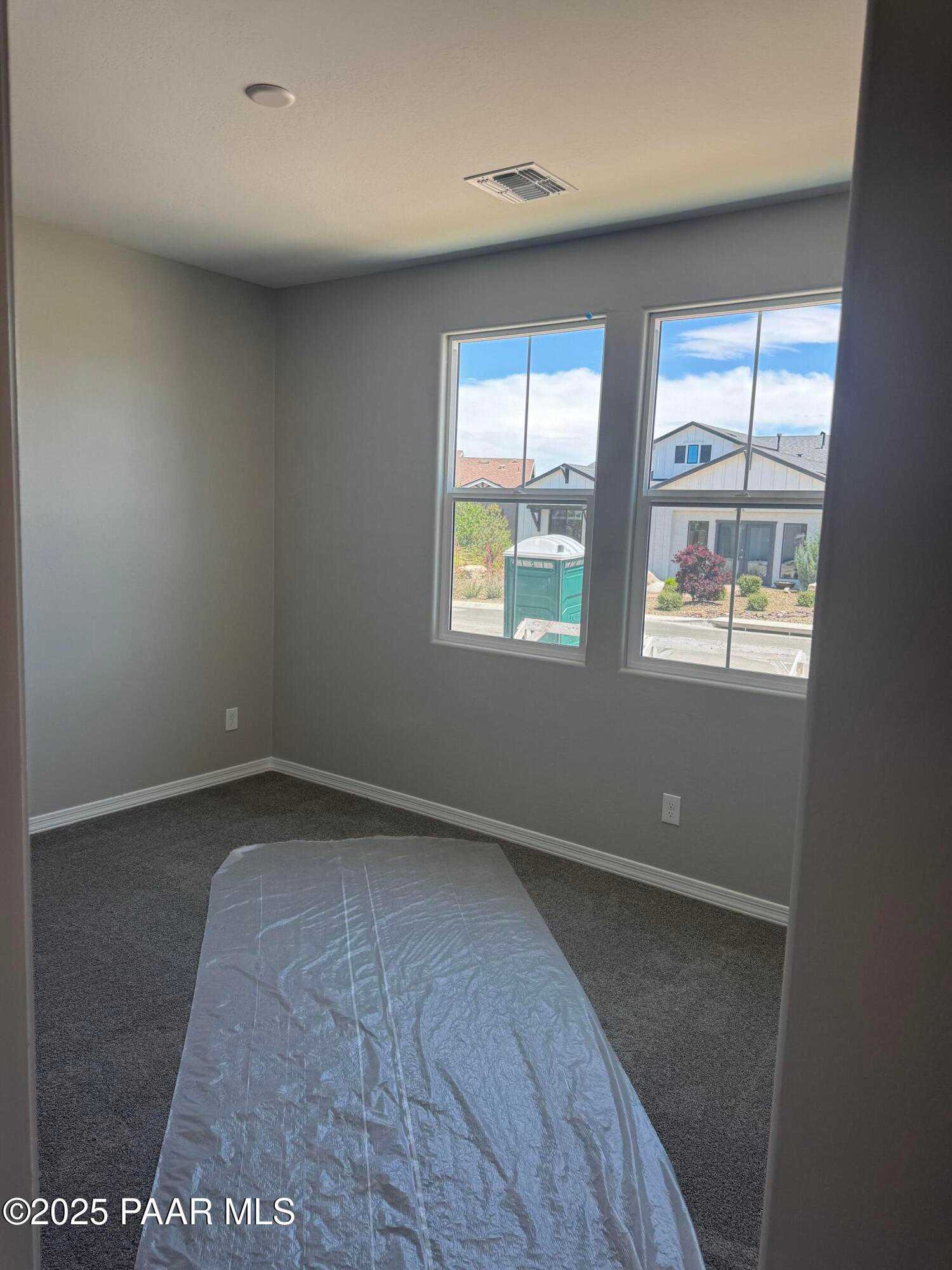 Bright empty bedroom with large dual windows and neighborhood view in Davidson Homes Durango II A, Prescott AZ