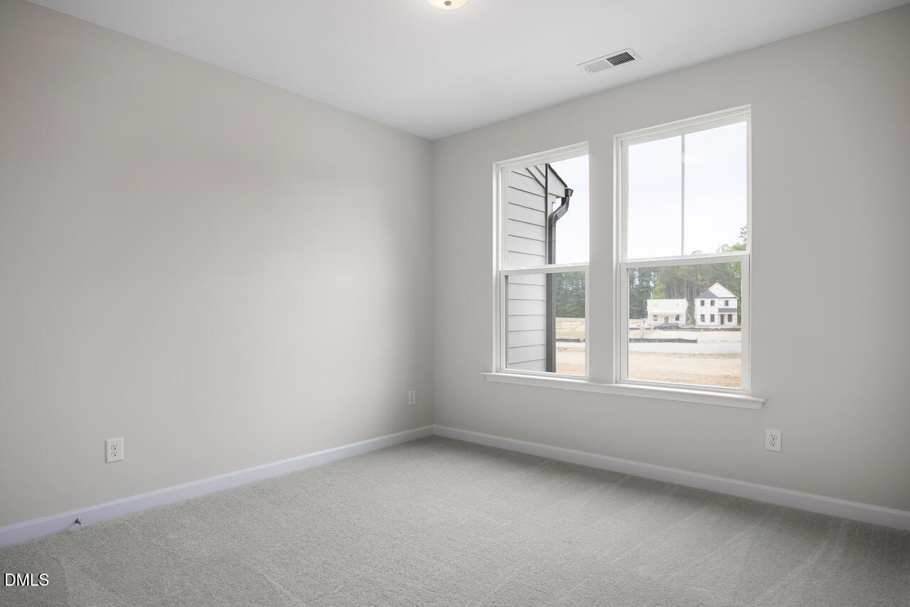 Bright, carpeted bedroom with large windows in The Mitchell Interior floor plan at Forestville Yard Townhomes, Knightdale.