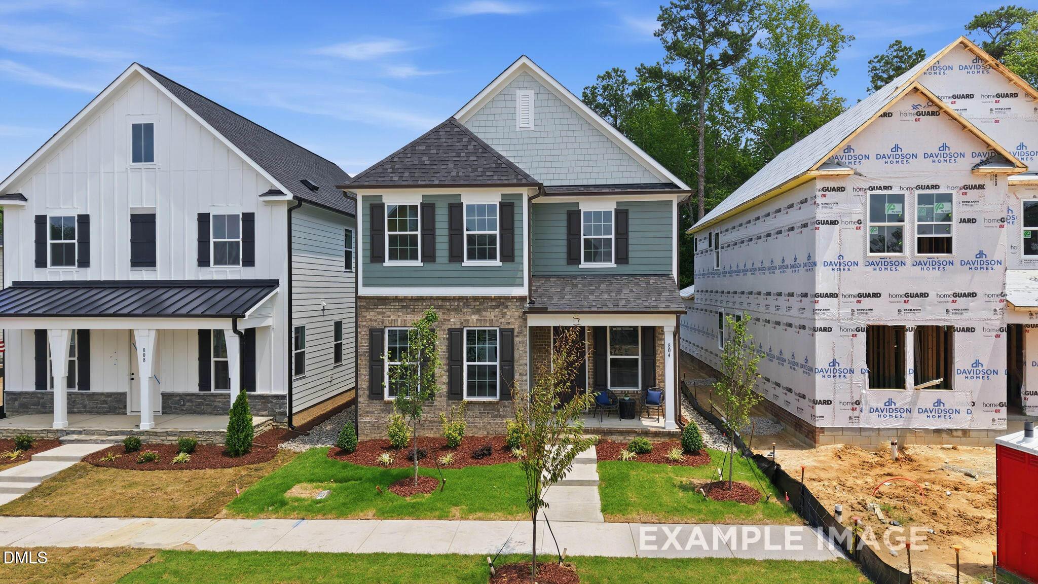 Two-story brick and siding homes with covered front porches under construction at Forestville Yard in Knightdale, North Carolina by Davidson Homes