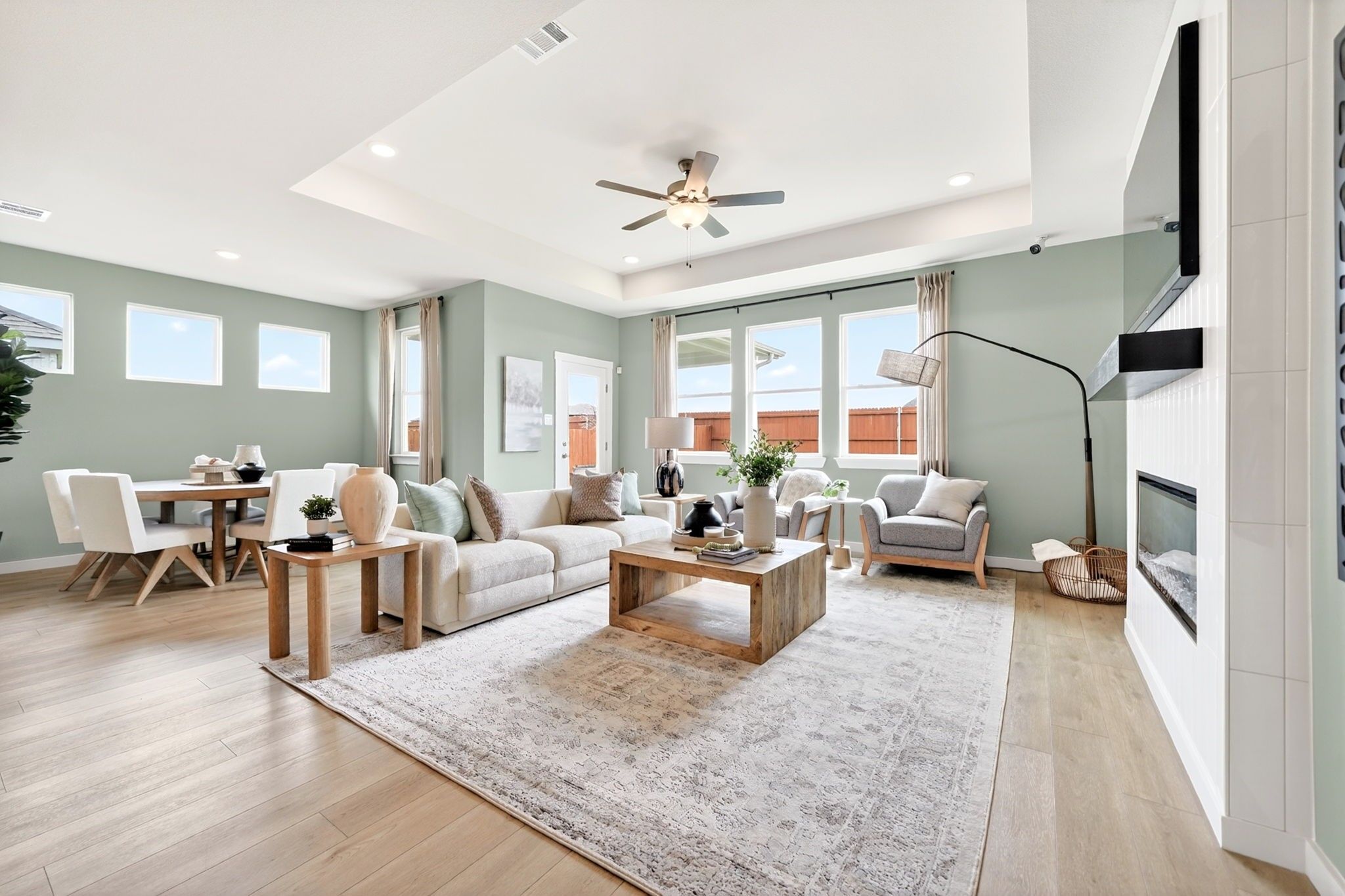 Bright open-concept living room with tray ceiling in The Laurel M floor plan at Parks at Foster Crossing, Anna, Texas.
