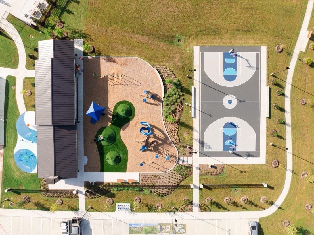 Aerial view of colorful playground with slides, swings, basketball court, and pavilion in Sierra Vista, Rosharon, Texas