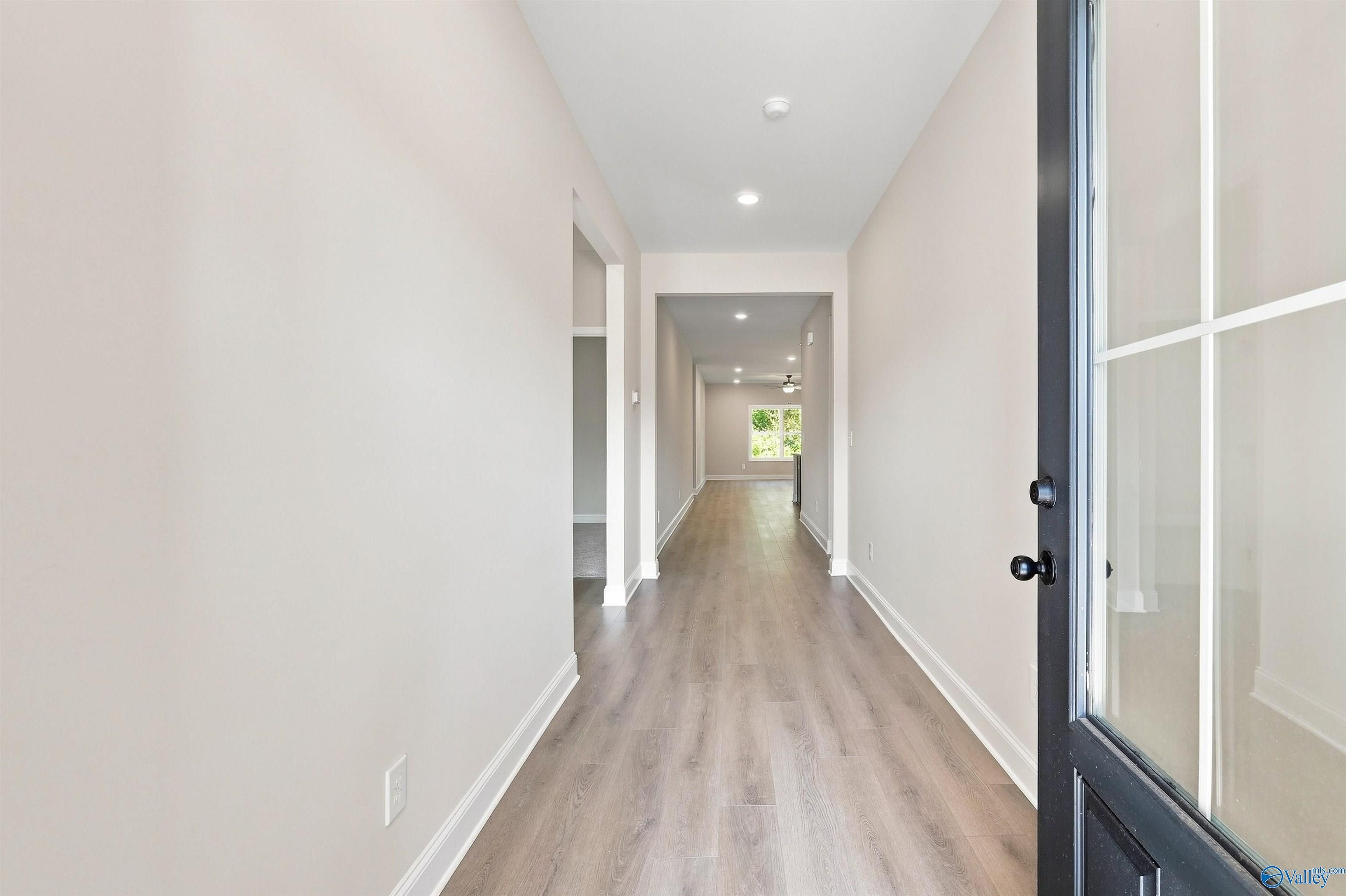 Bright entryway with wood-look flooring leading to open living area in The Daphne floor plan, Spragins Cove, Huntsville.