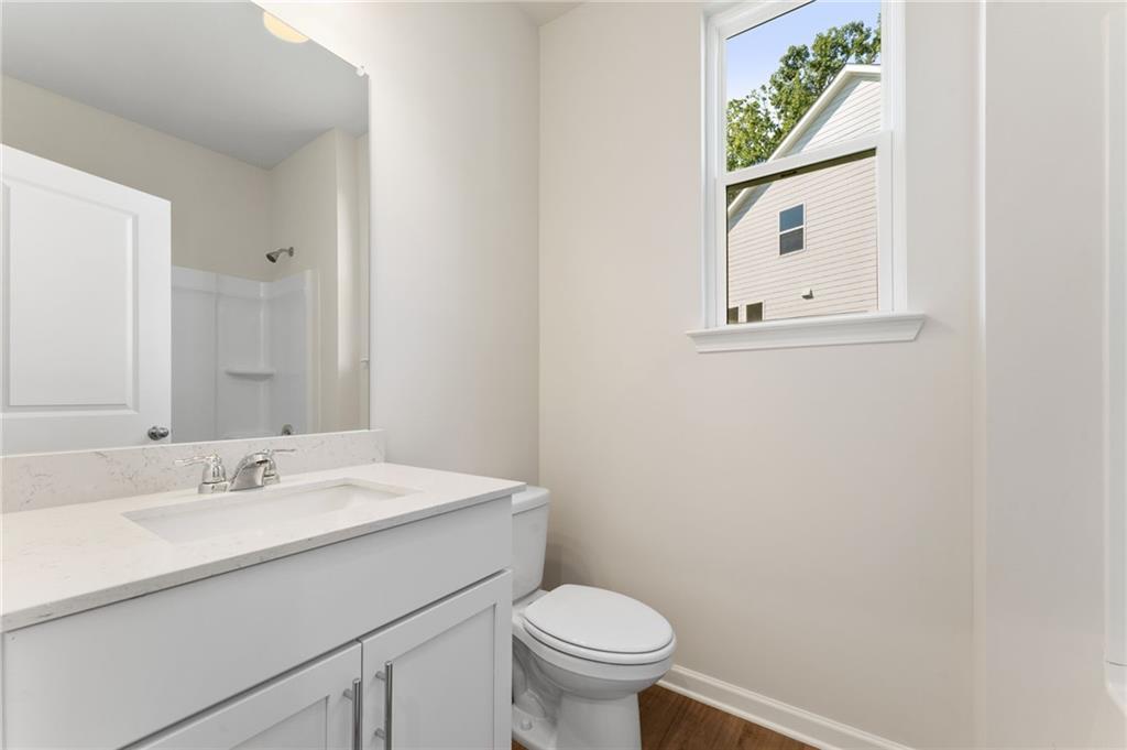 Modern full bathroom with white vanity, walk-in shower, and window view in Davidson Homes The Willow B, Riverwood, Dallas, Georgia