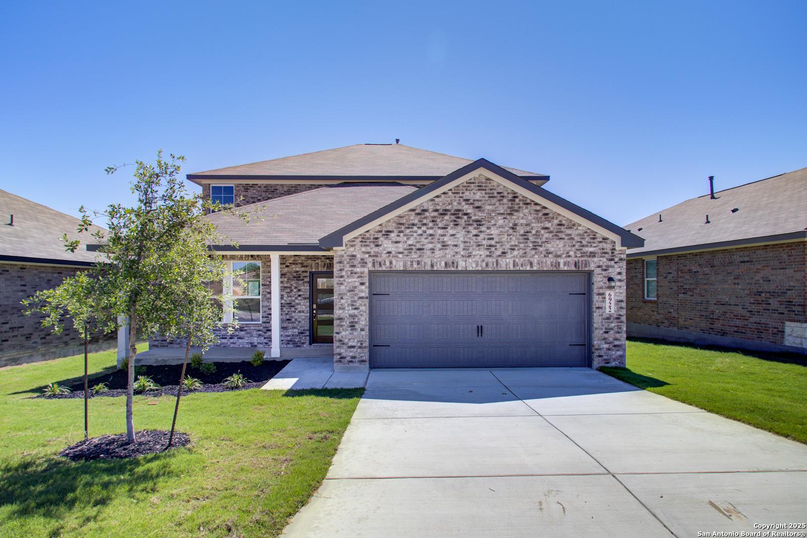 Modern two-story brick home with 2-car garage, front porch, and landscaped yard in Comanche Ridge, San Antonio, Texas - Davidson Homes The Douglas G