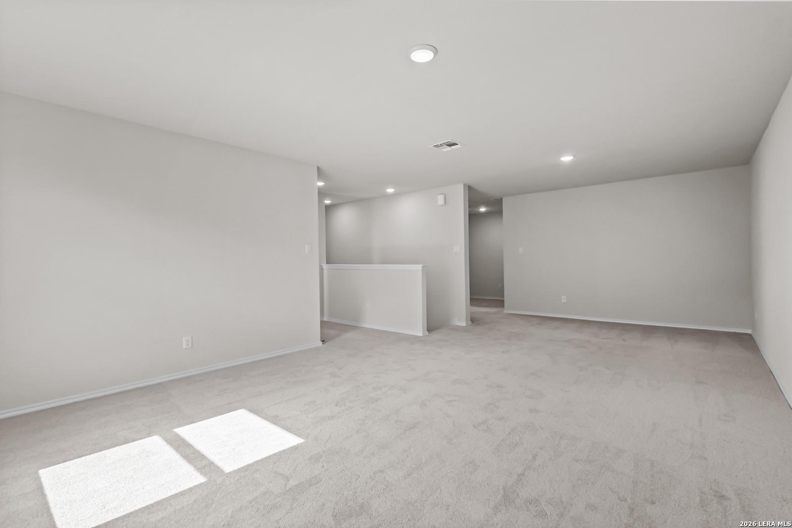 Spacious carpeted game room in The Douglas C floor plan by Davidson Homes at Hannah Heights in Seguin, Texas.