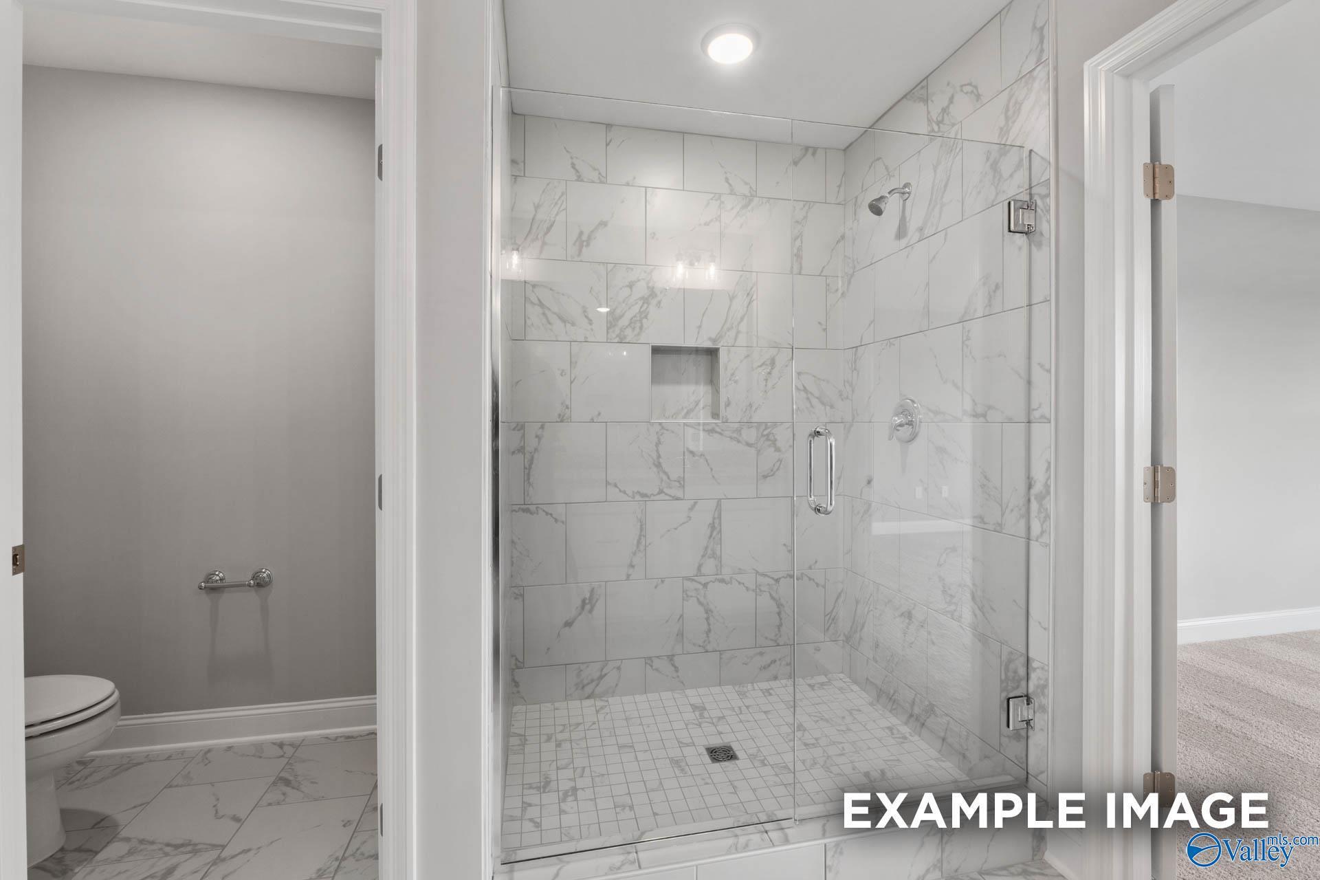Modern master bathroom with frameless glass shower, subway tile walls, and dual vanity in Davidson Homes The Shelby B, New Market, Alabama