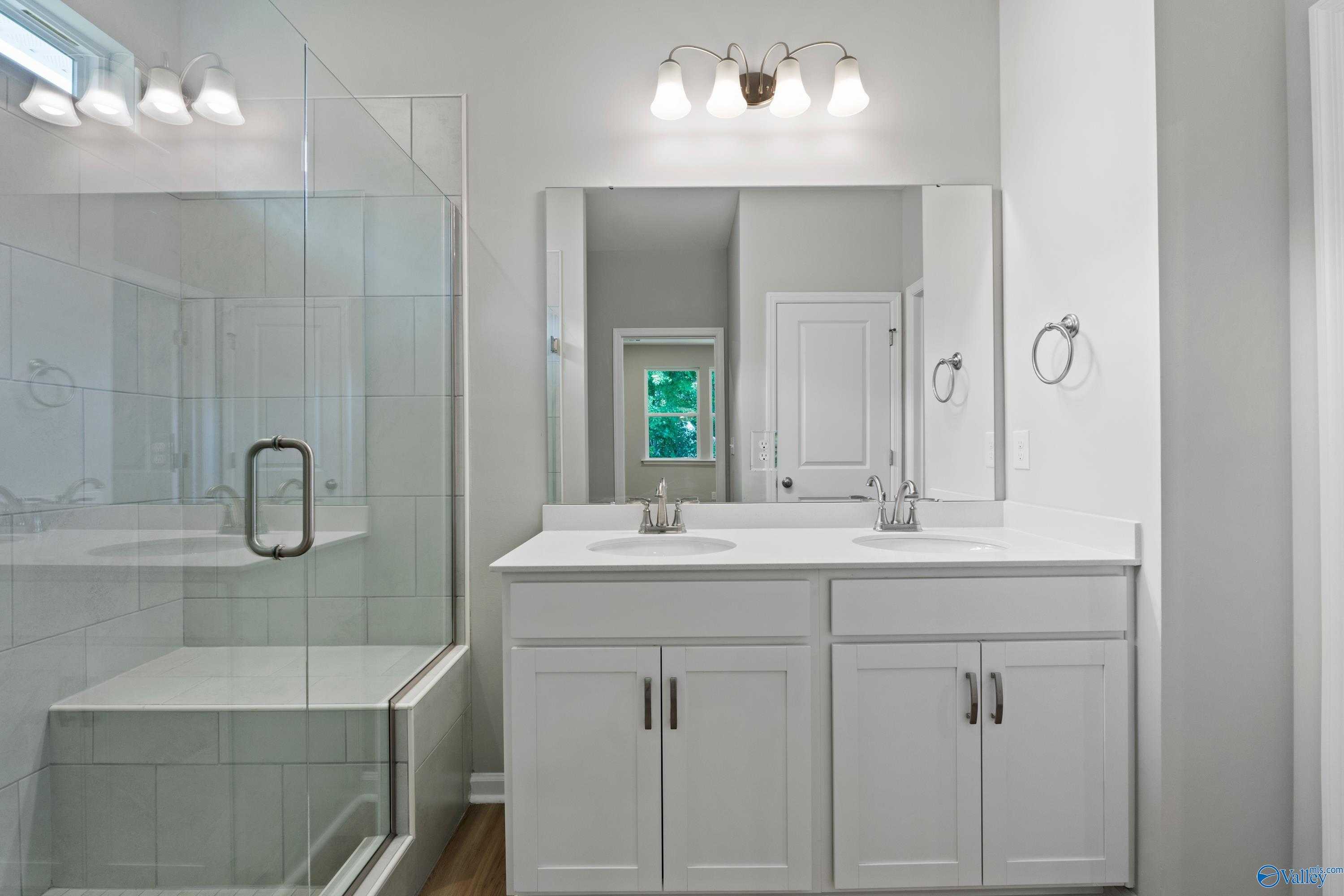 Modern master bathroom featuring frameless glass shower and double vanity in Davidson Homes The Polaris, Fayetteville, TN