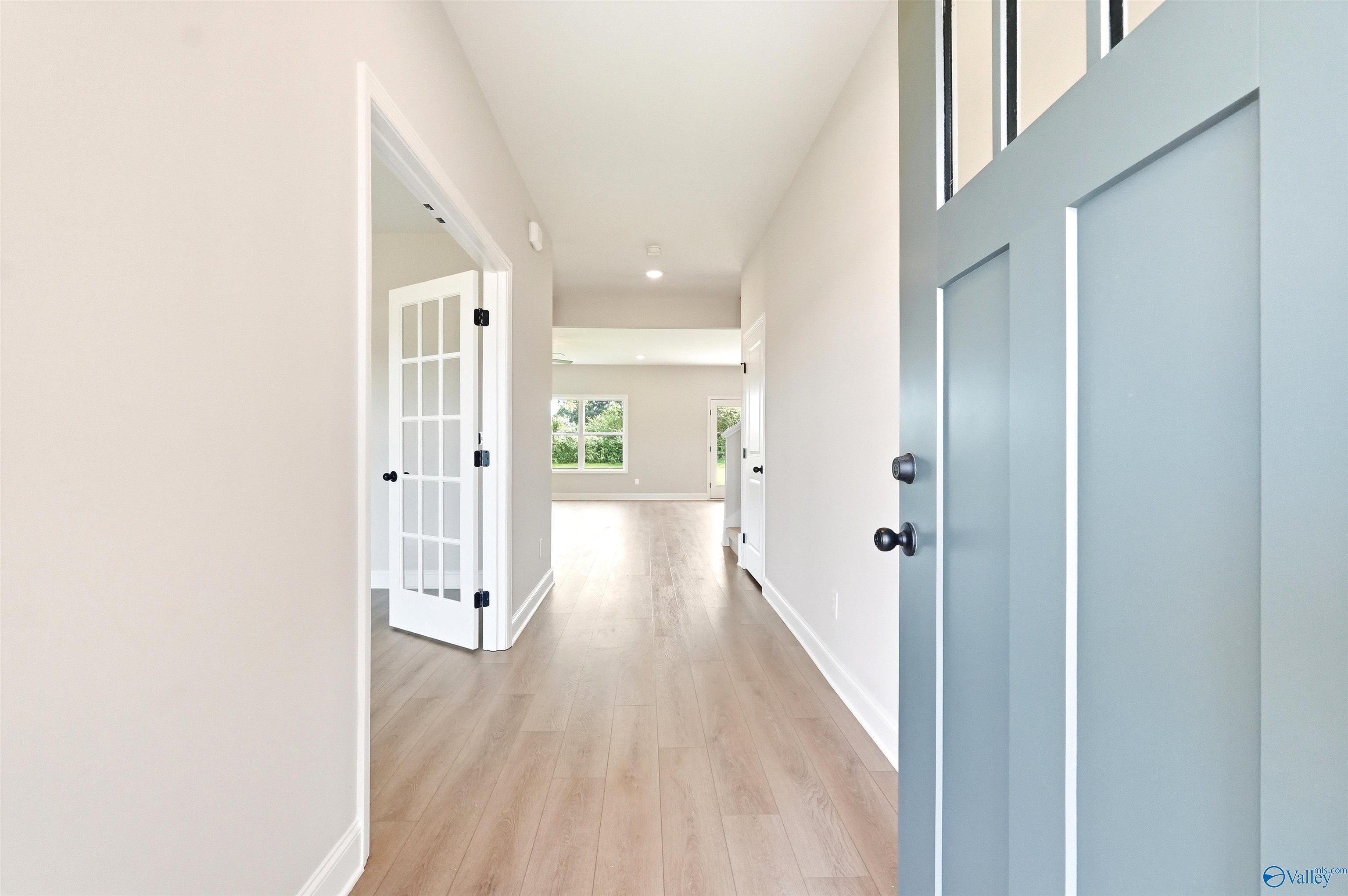 Bright foyer entry with French doors and wood floors in The Chelsea D floor plan at Berry Cove, New Market, Alabama.