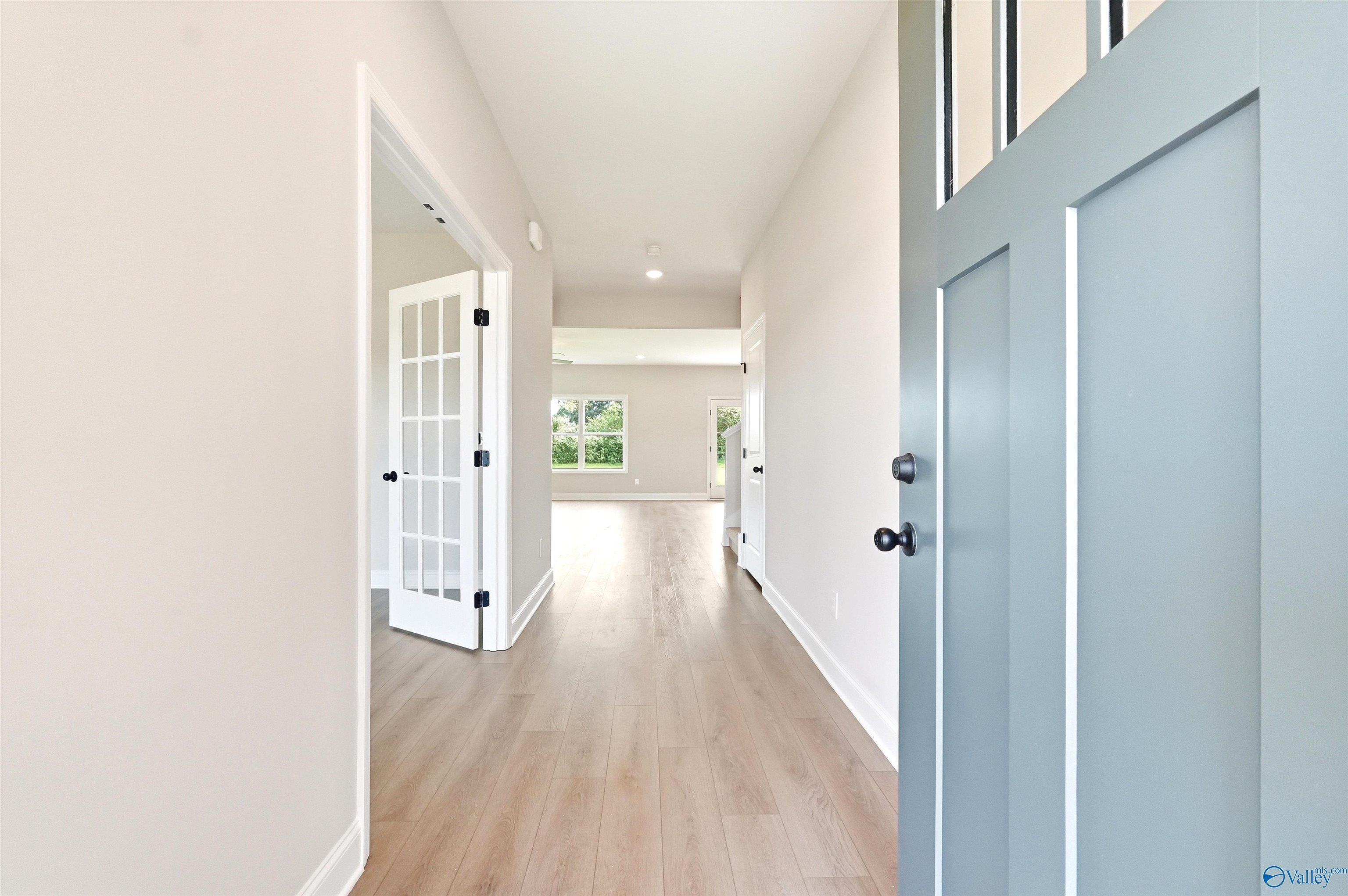 Bright foyer entry with French doors and wood floors in The Chelsea D floor plan at Berry Cove, New Market, Alabama.