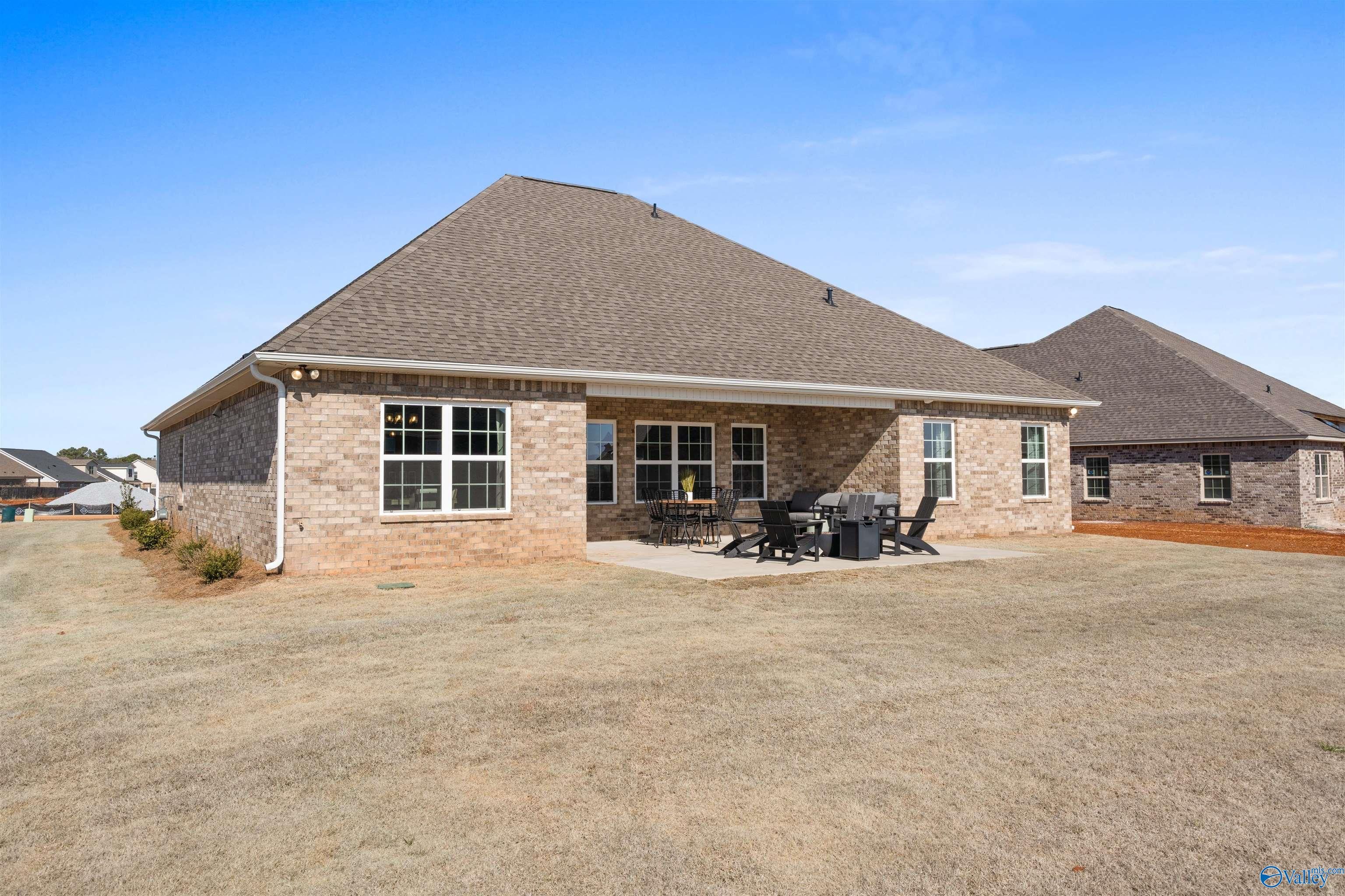Covered back patio with outdoor seating in spacious backyard of Davidson Homes The Rockford B in Madison, Alabama