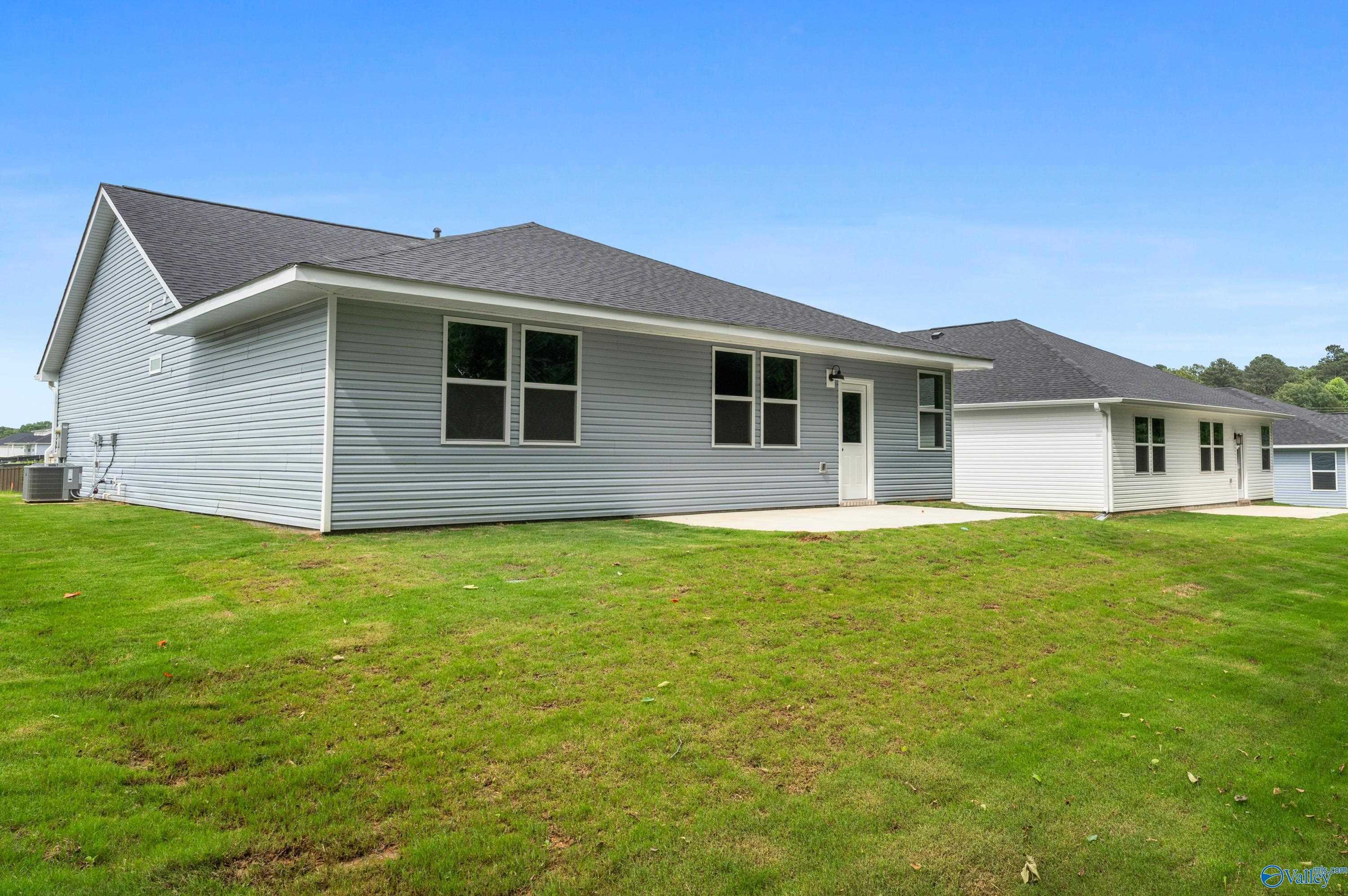 Gray single-story 3-bedroom home with 2-car garage, concrete patio, and lush green yard in Bailey Park, Fayetteville, Tennessee