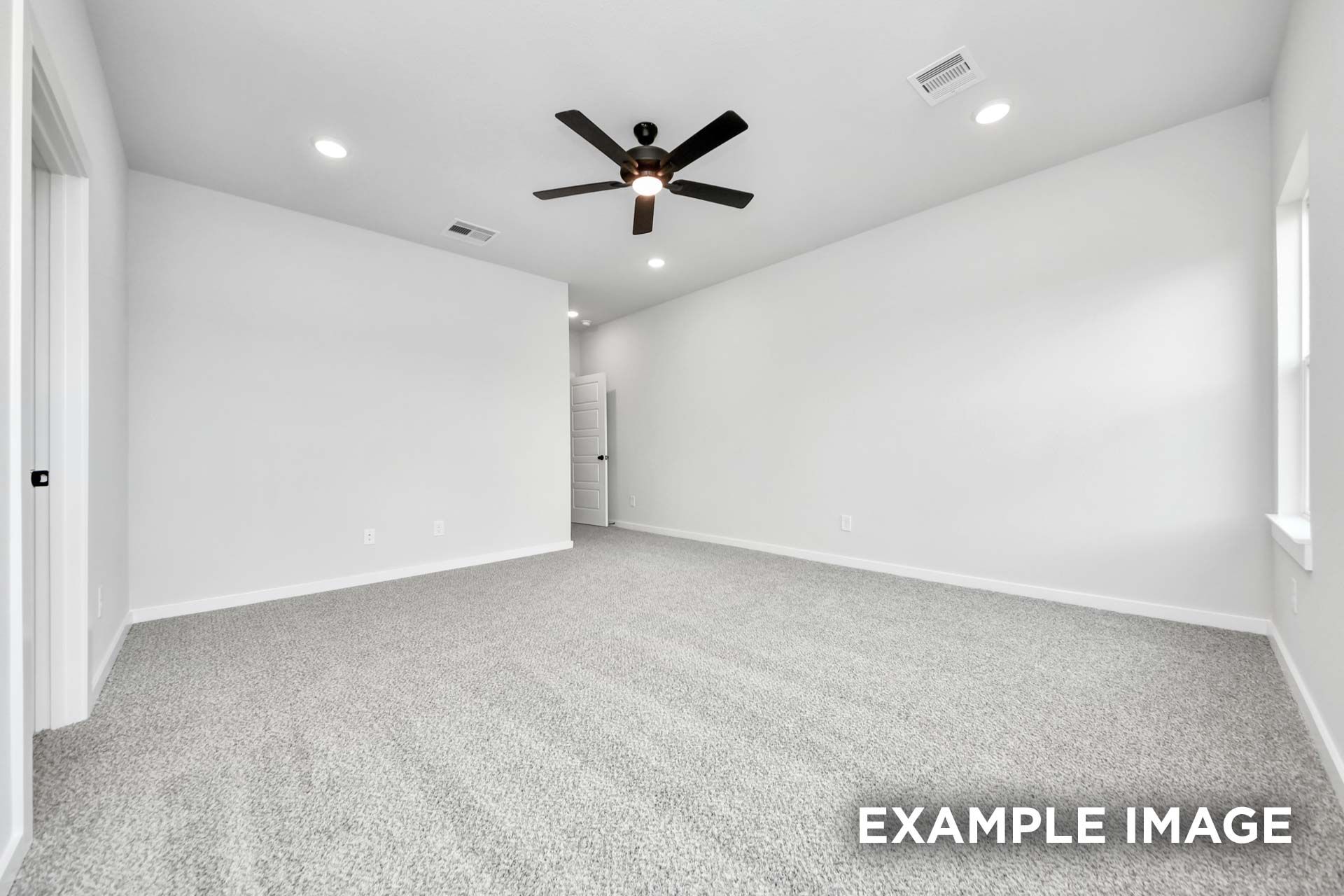 Spacious master bedroom in The Sorrento home design featuring neutral walls, plush carpet, and a modern ceiling fan.