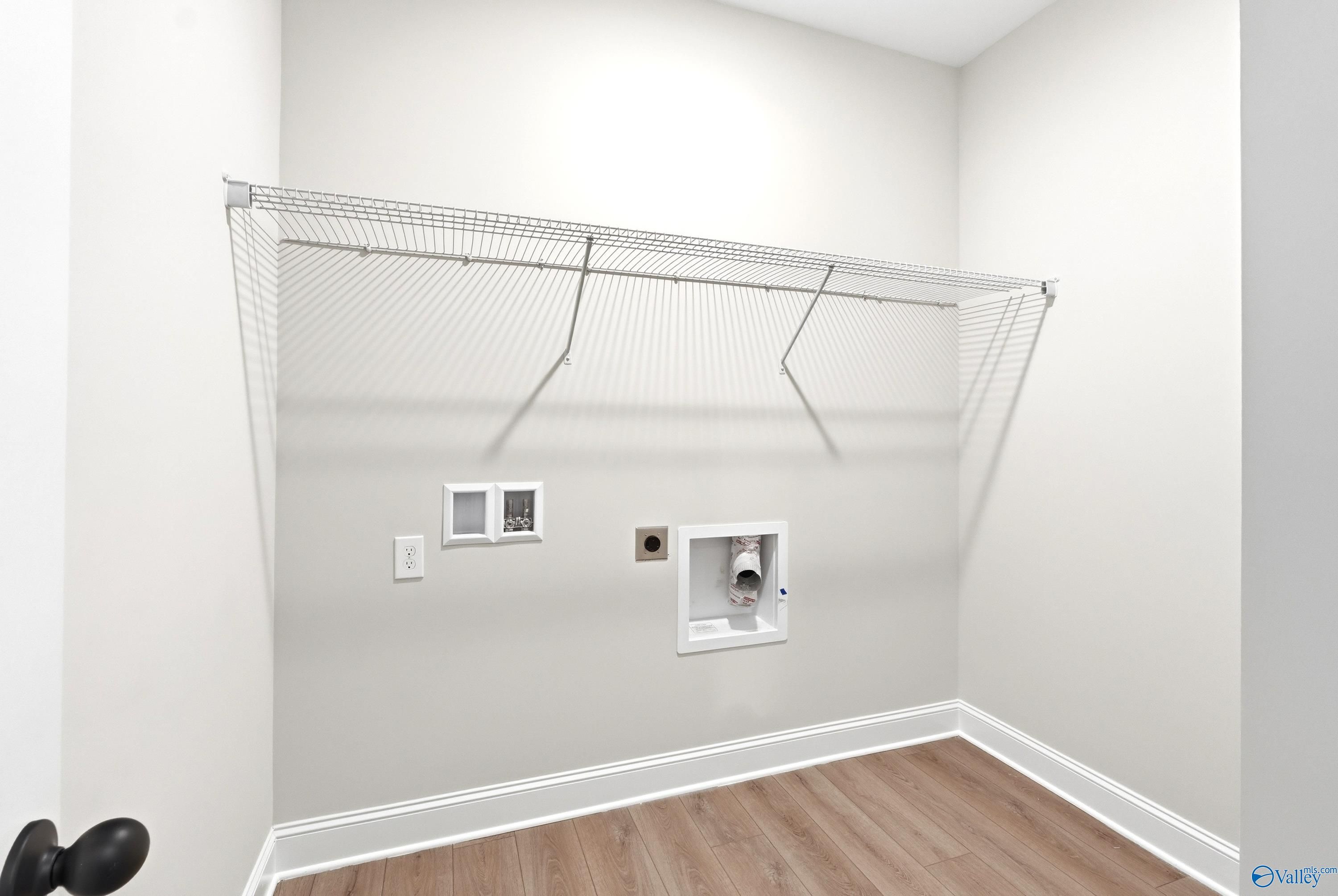 Laundry room with wire shelving and utility hookups in The Daphne C floor plan at Flint Meadows, New Market, Alabama.