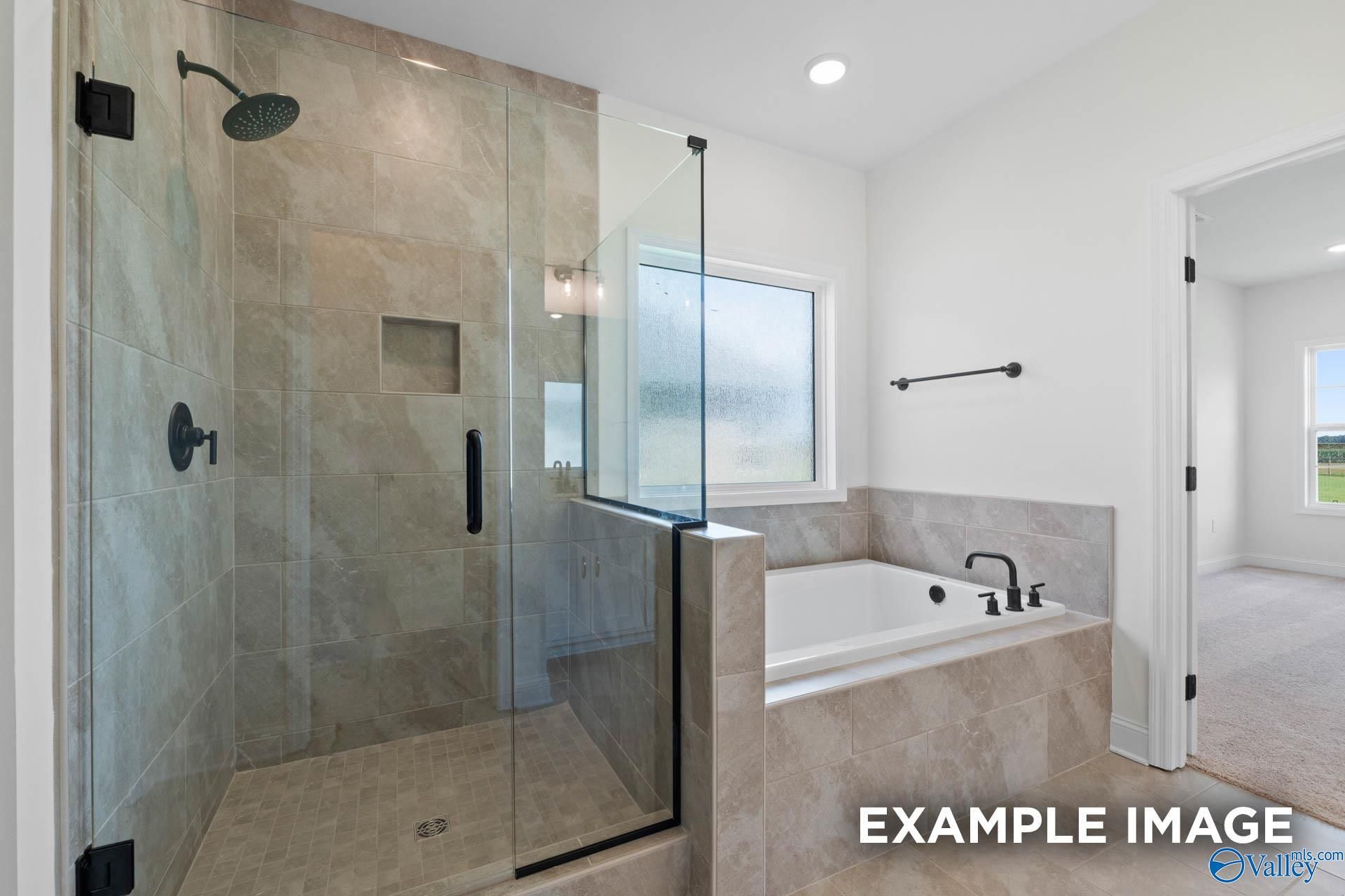 Modern bathroom with tiled walk-in shower and soaking tub in The Rockford B floor plan at Briercreek, Meridianville, AL.