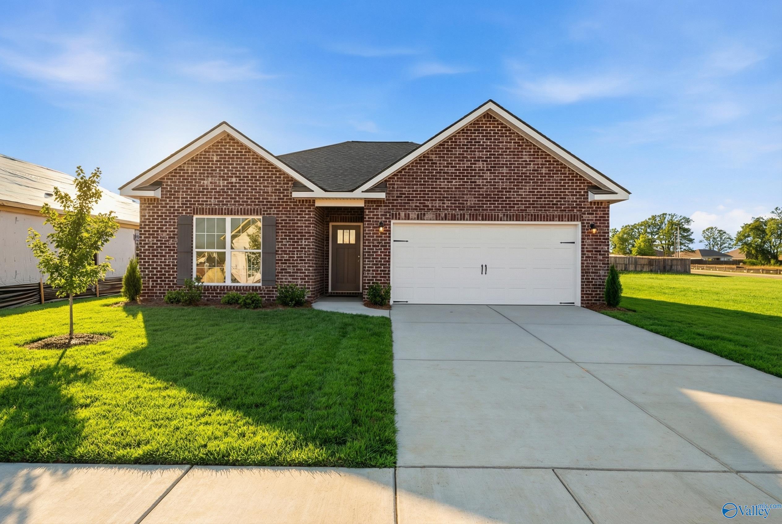 Modern brick single-story home with 2-car garage, manicured lawn, and blue sky in Lynn Meadows, Meridianville, Alabama - Davidson Homes Asheville C