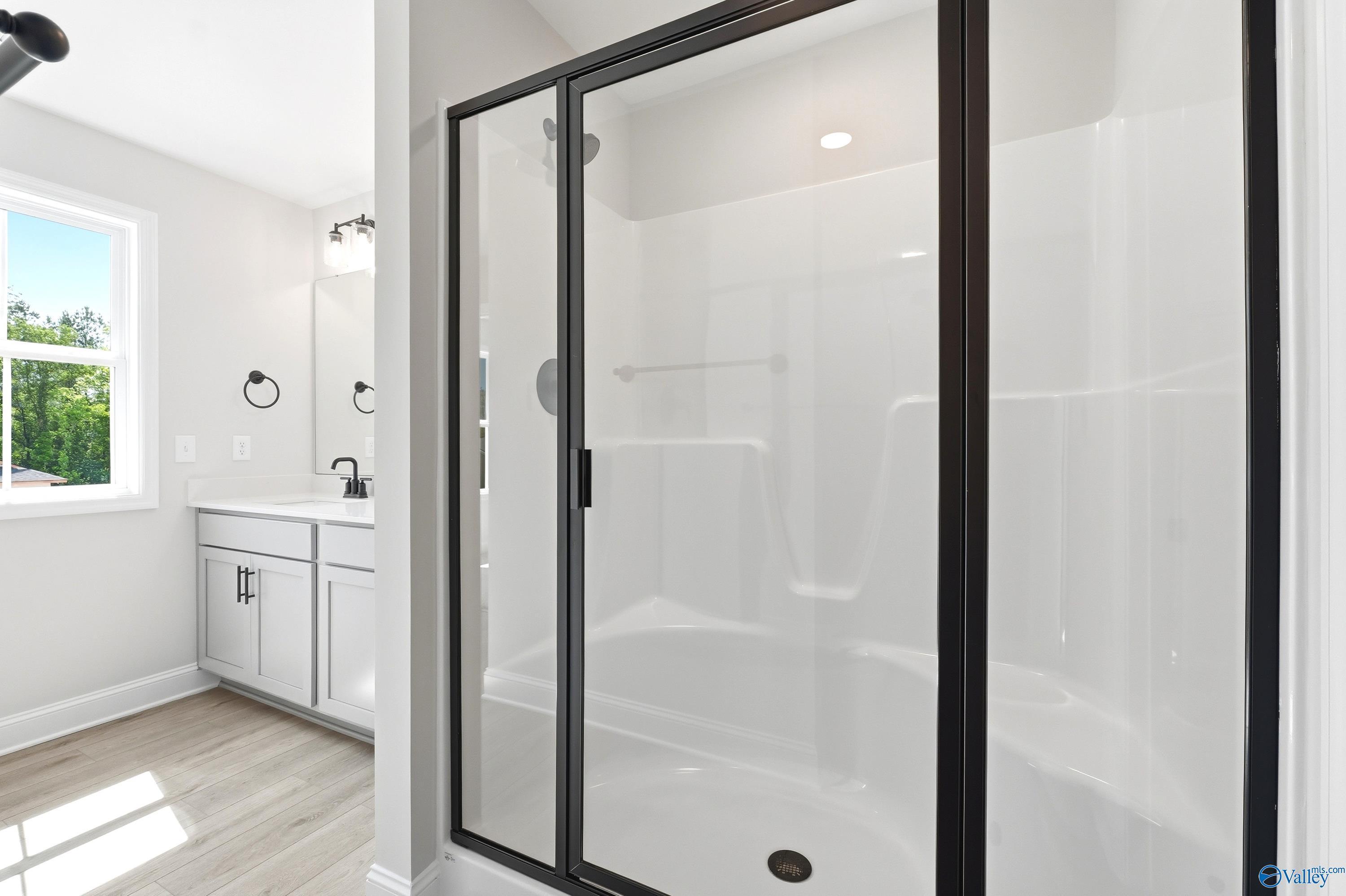 Modern bathroom with glass-enclosed shower and vanity in The Russell A floor plan by Davidson Homes in Huntsville, Alabama.