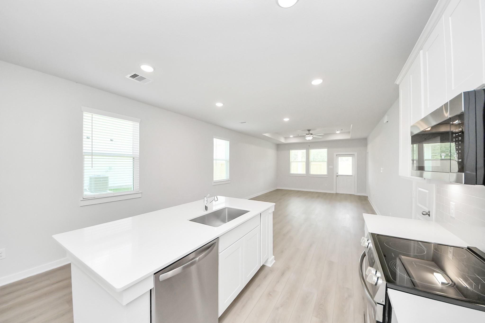 Bright open-concept kitchen and living area in The Frio F floor plan by Davidson Homes in Liberty Estates, Cleveland, TX.