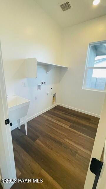 Laundry room with utility sink, wood-look flooring, and shelving in The Aurea C floor plan, Hidden Hills, Prescott, AZ.
