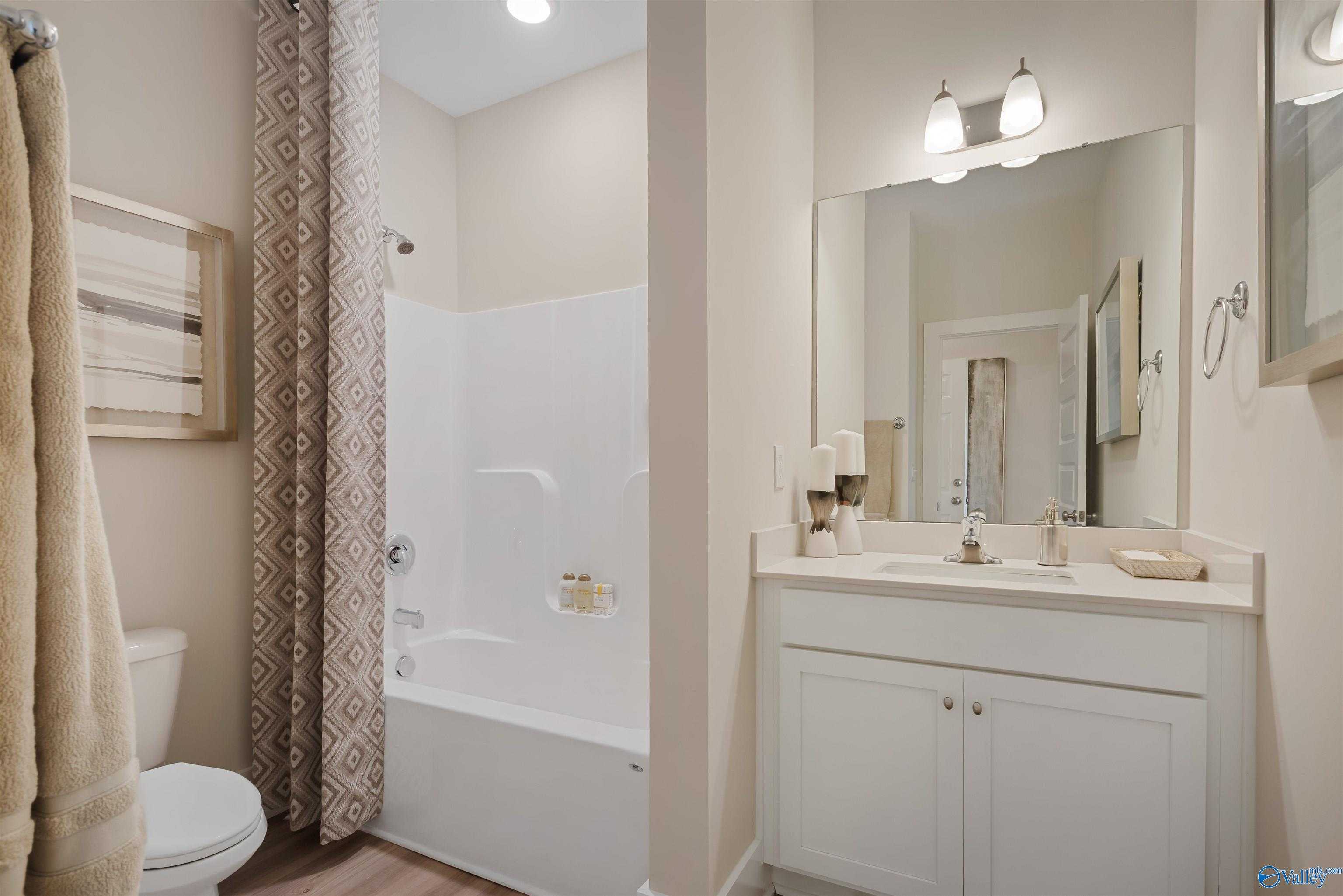 Modern bathroom with tub-shower combo, double vanity, and neutral tones in Davidson Homes The Everett, New Market, AL