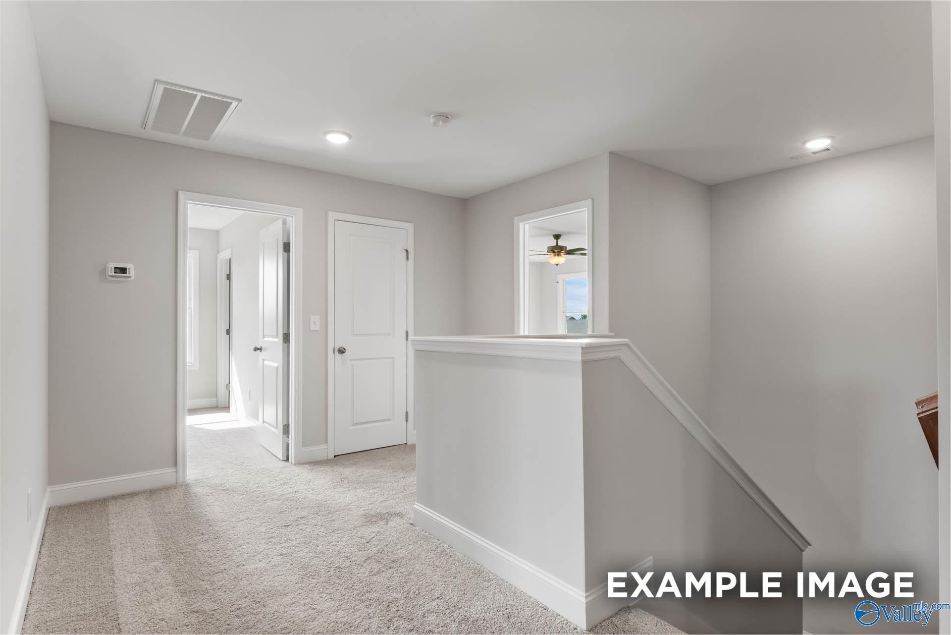 Upstairs hallway with white doors and overlook railing in 4-bedroom The Chelsea D home by Davidson Homes, Berry Cove, Alabama