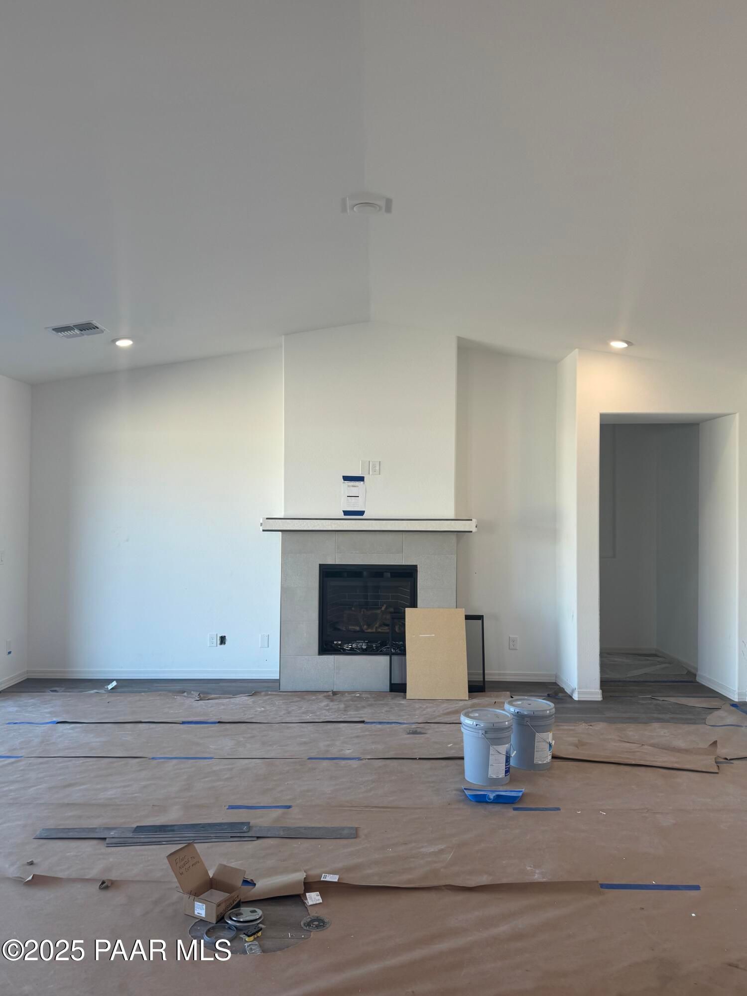 Spacious great room with vaulted ceiling, stone gas fireplace, and recessed lighting in Davidson Homes The Summit A, Prescott, Arizona