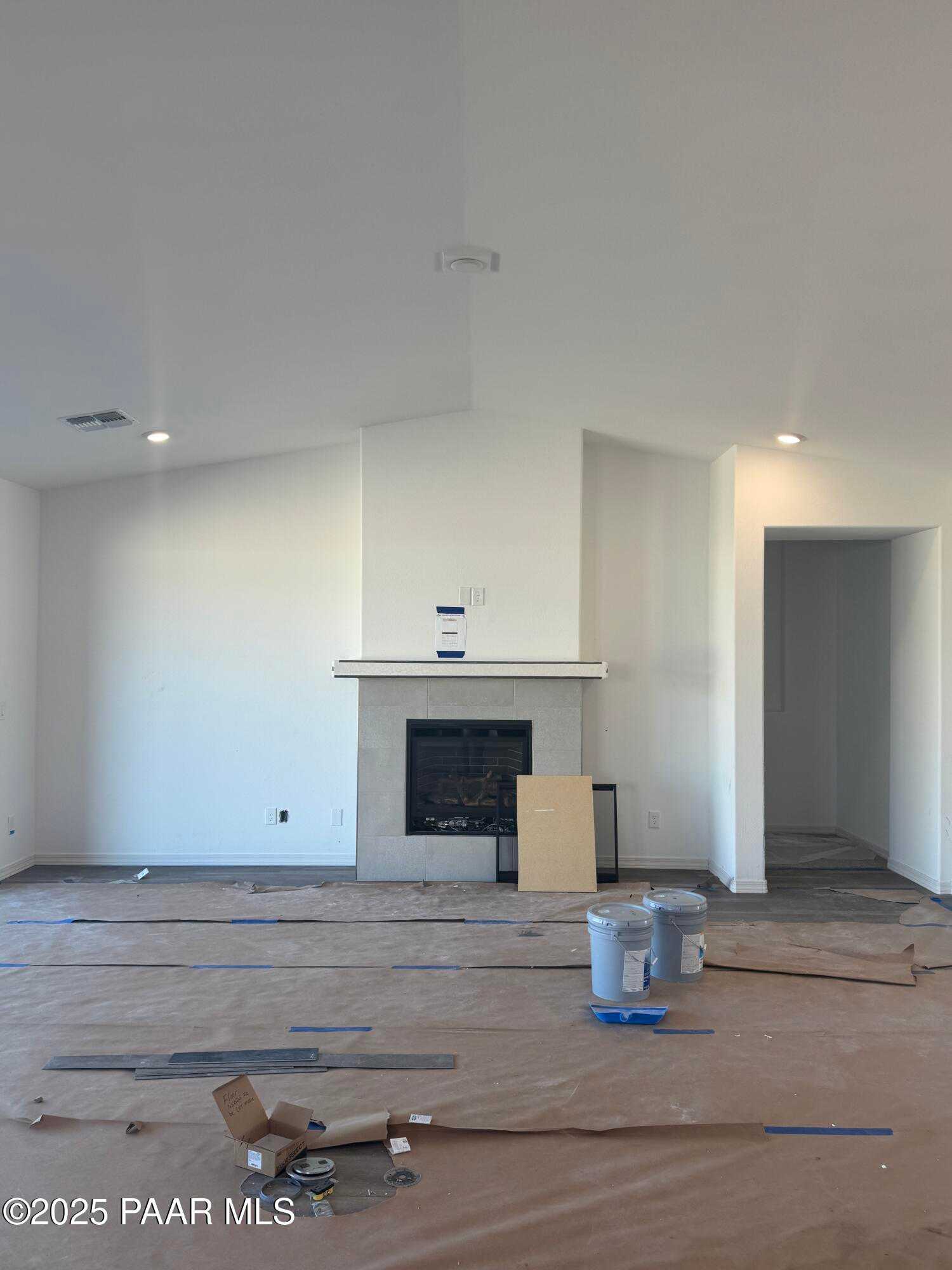 Spacious great room with vaulted ceiling, stone gas fireplace, and recessed lighting in Davidson Homes The Summit A, Prescott, Arizona
