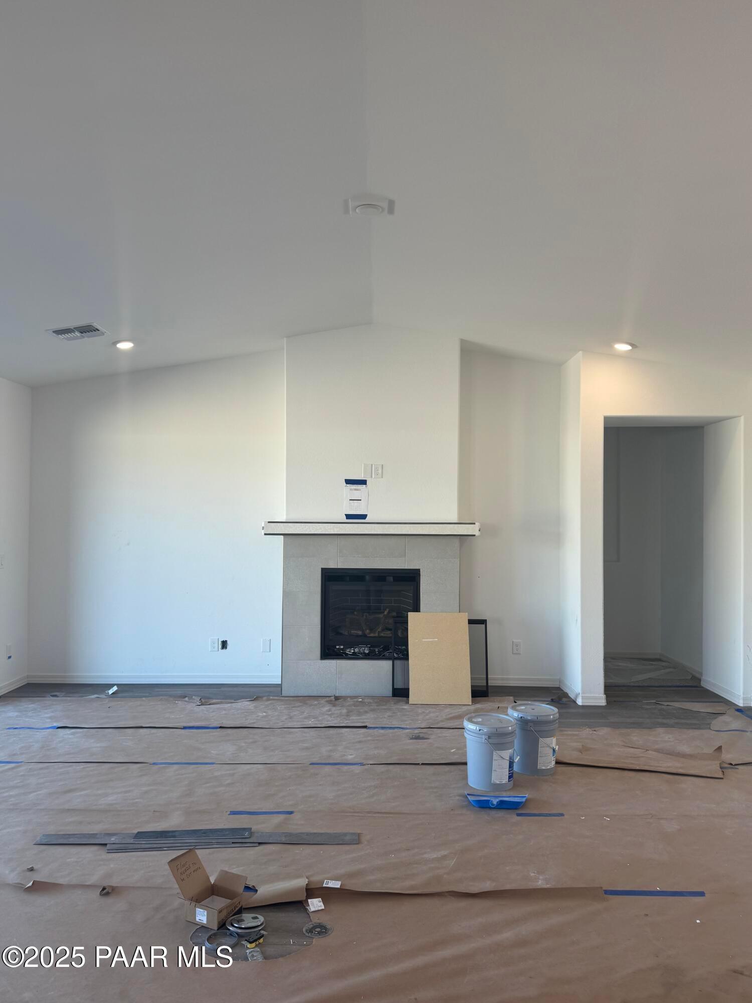 Spacious great room with vaulted ceiling, stone gas fireplace, and recessed lighting in Davidson Homes The Summit A, Prescott, Arizona