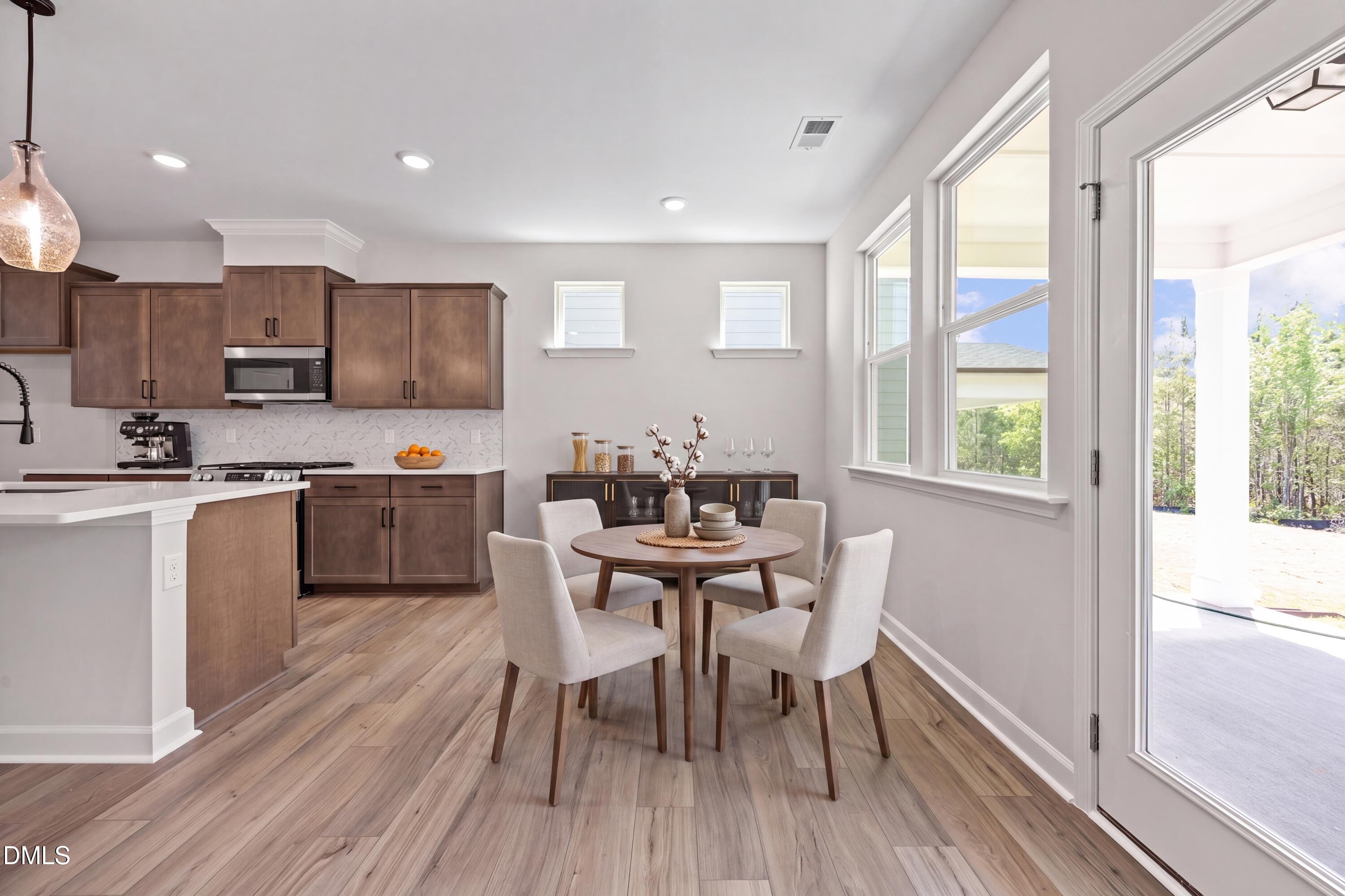 Open-concept kitchen and dining area in The Willow D floor plan by Davidson Homes at Wendell Ridge in Wendell, NC.