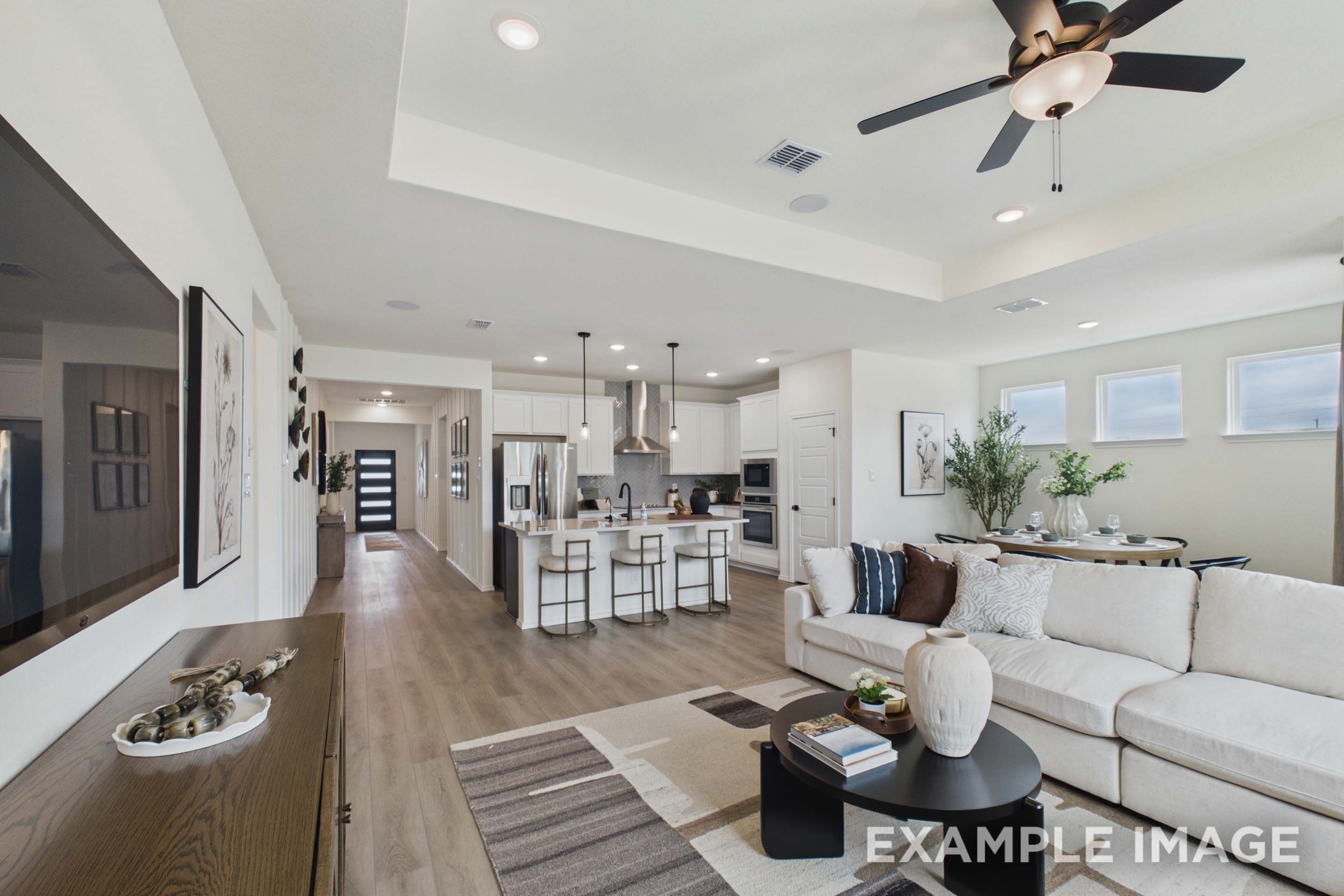 Open-concept living room and kitchen in The Laurel G home design by Davidson Homes featuring modern finishes and island.
