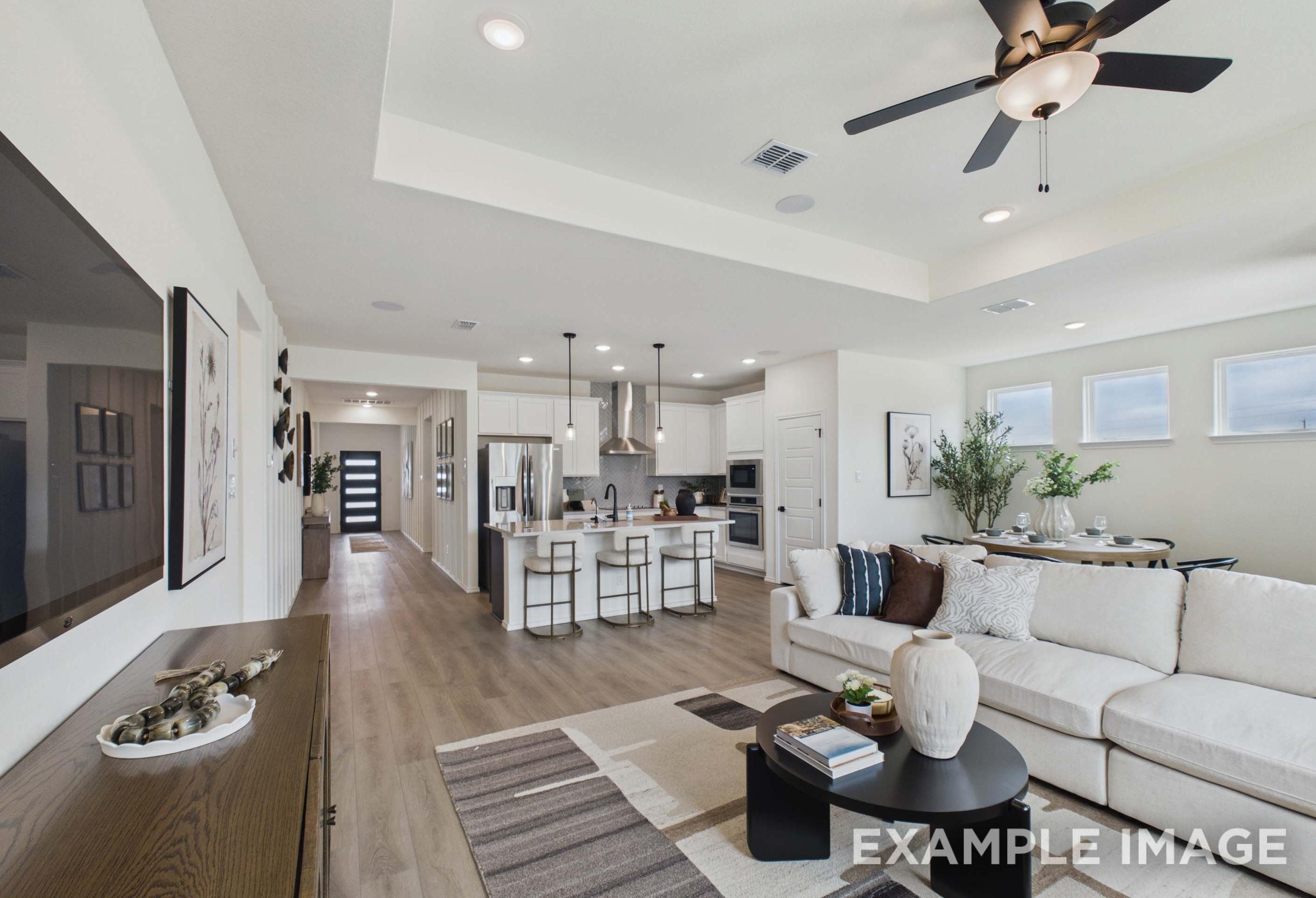 Open-concept living room and kitchen in The Laurel G home design by Davidson Homes featuring modern finishes and island.
