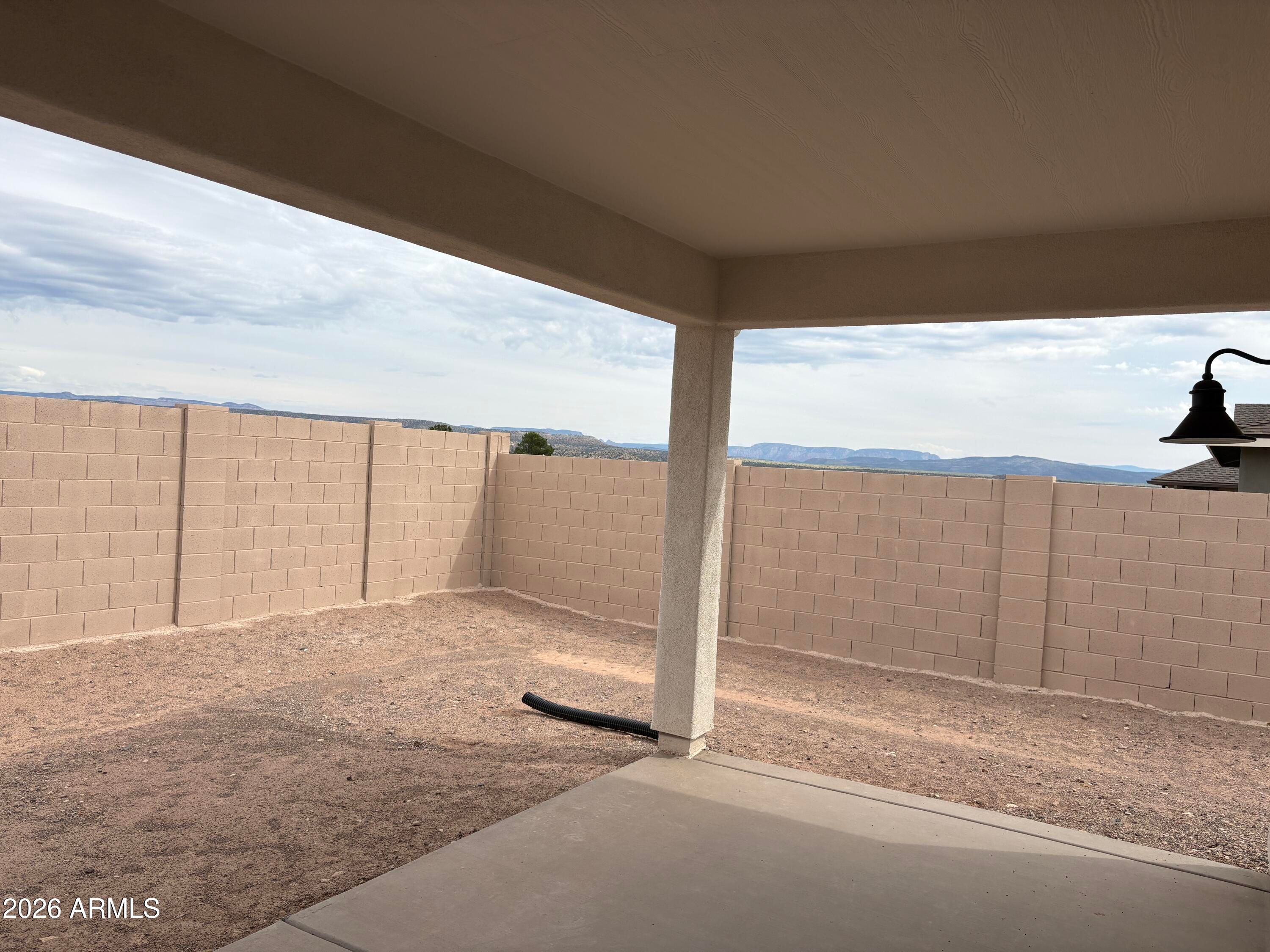 Covered patio with block fence backing to scenic mountain views at Davidson Homes The Evergreen B in Vineyards at Cottonwood, Arizona