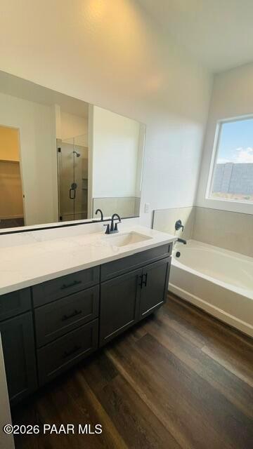 Modern primary bathroom with dark vanity, white quartz countertop, and deep soaking tub in The Aurea C, Hidden Hills.