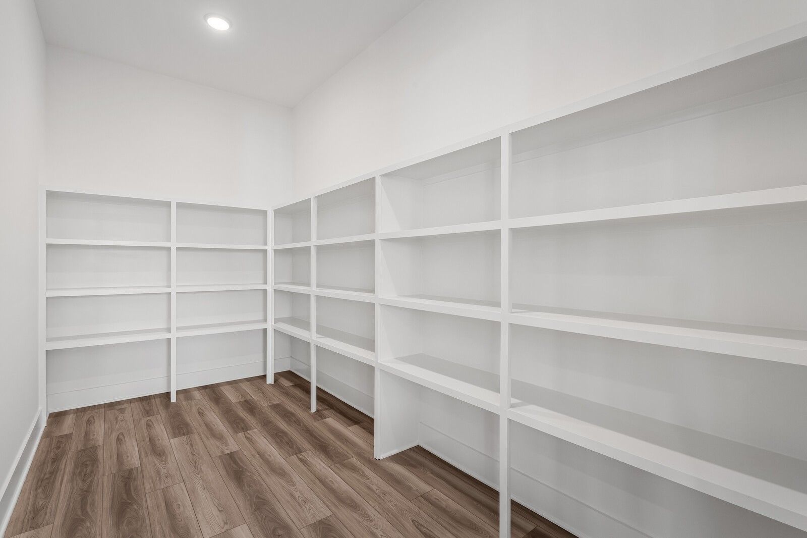 Spacious walk-in closet with white built-in shelves and hardwood floors in Davidson Homes The Alston A, Murfreesboro, TN