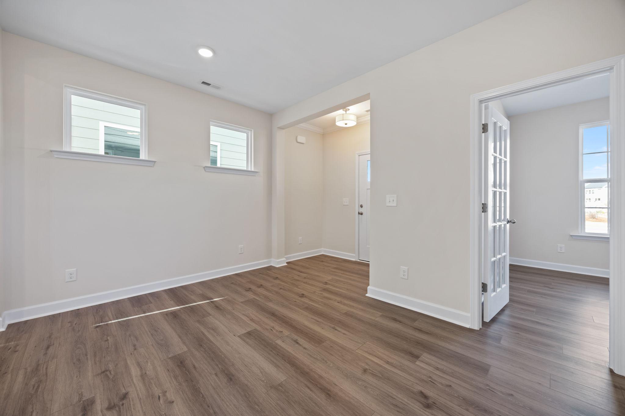 Bright home interior at Forestville Yard in Knightdale, NC by Davidson Homes with wood flooring and French door entryway.