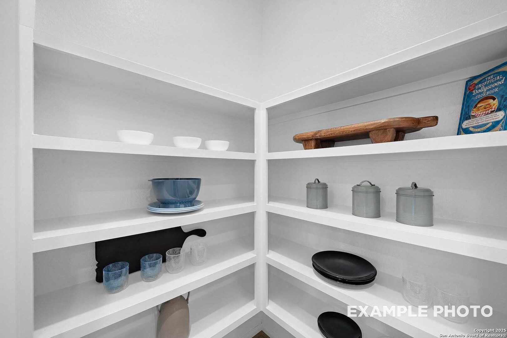 Spacious corner pantry with white shelves, bowls, glasses, canisters in Davidson Homes San Marcos D, Agave, San Antonio
