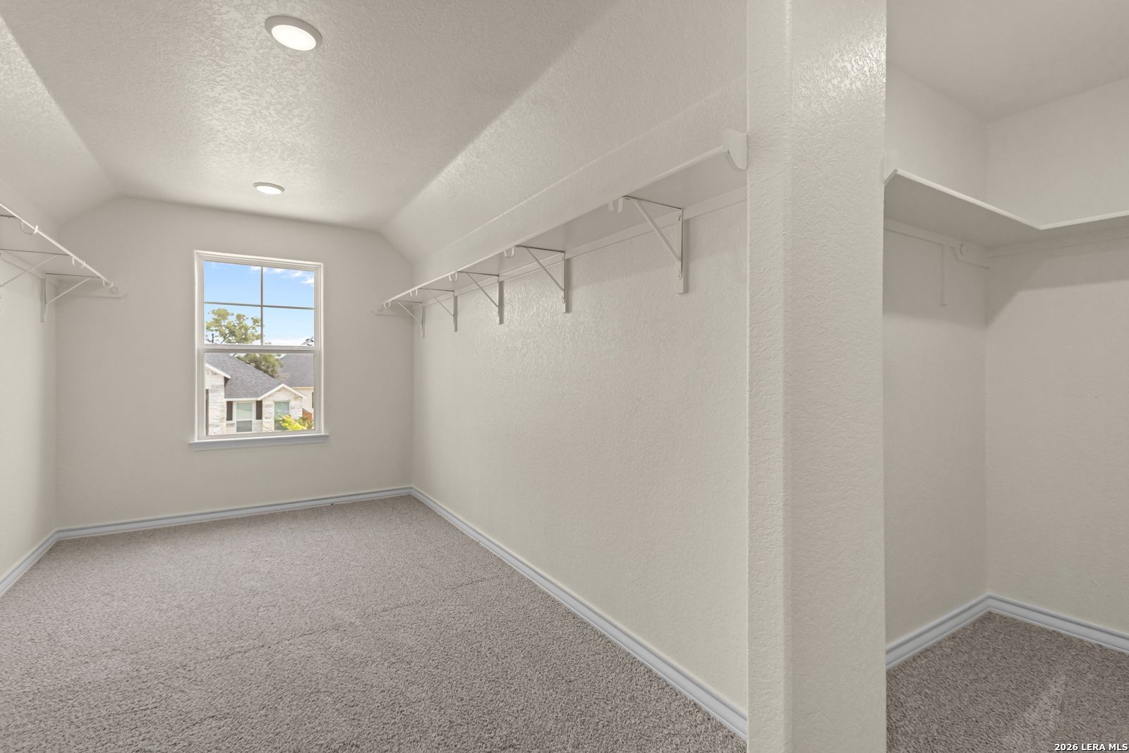 Spacious walk-in closet with shelving and natural light in The Danbury H model home, The Reserve at Potranco Oaks.