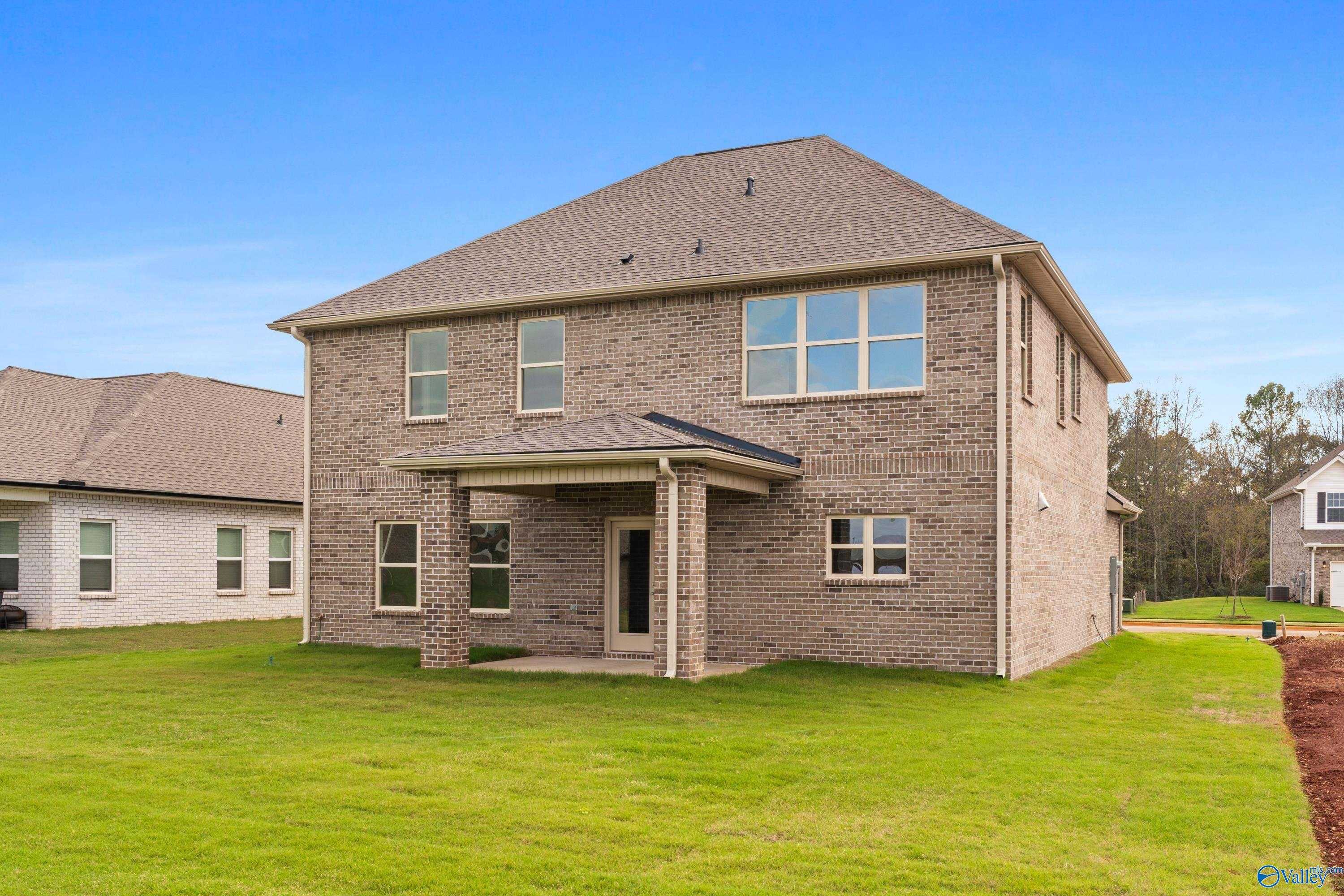 Two-story brick home with gabled roof, covered porch, large windows, and green lawn in Creekside, Harvest, Alabama - Davidson Homes Chelsea C