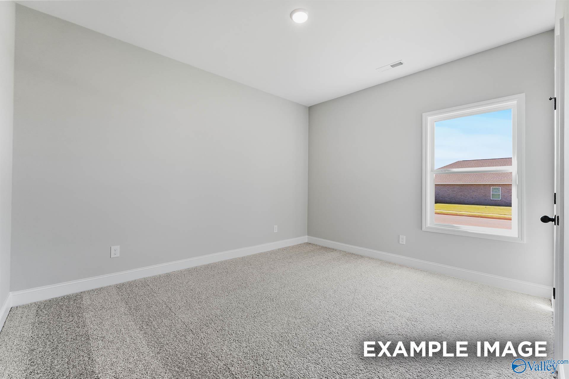 Bright secondary bedroom with gray walls, carpet floor, and window view in Davidson Homes The Daphne C, Athens, Alabama