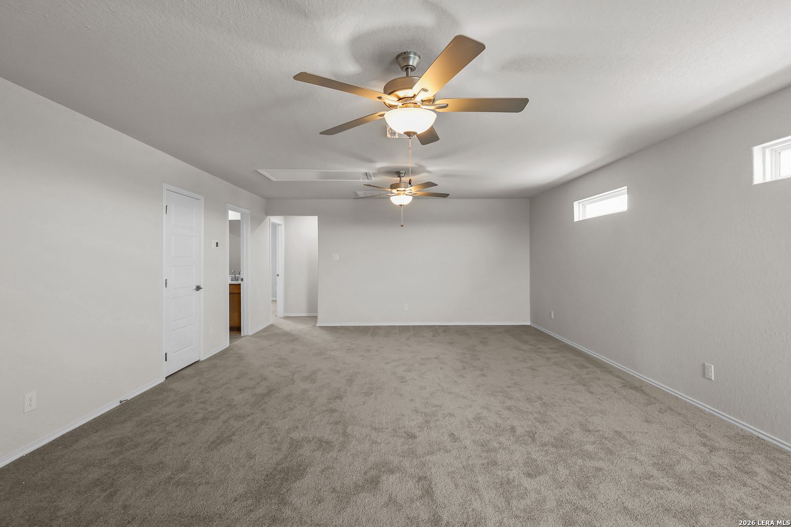 Spacious carpeted game room with dual ceiling fans in The San Marcos F floor plan at Rayburn Valley, San Antonio.