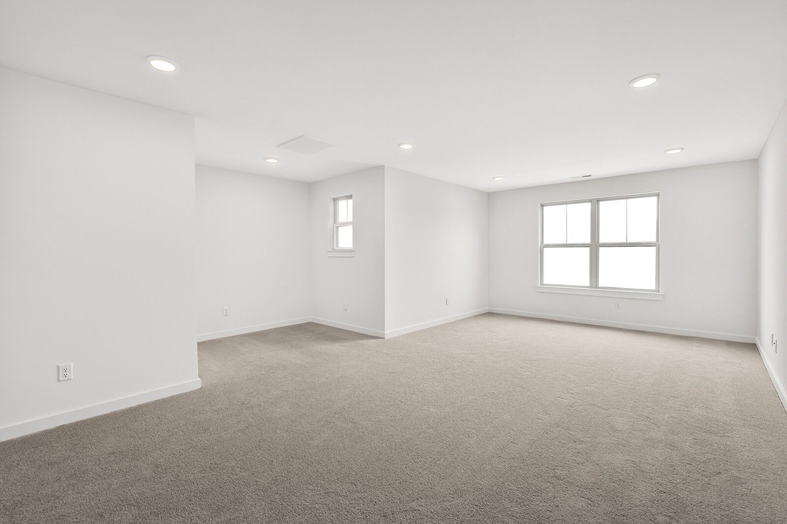 Spacious empty upstairs bedroom with white walls, beige carpet, recessed lights, and large windows in 5-bedroom Ridgeport C home, Gallatin TN