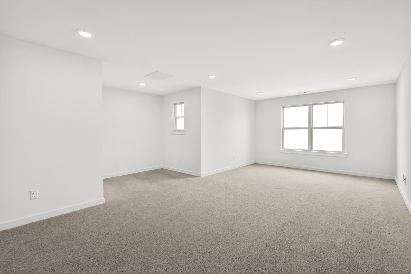 Spacious empty upstairs bedroom with white walls, beige carpet, recessed lights, and large windows in 5-bedroom Ridgeport C home, Gallatin TN