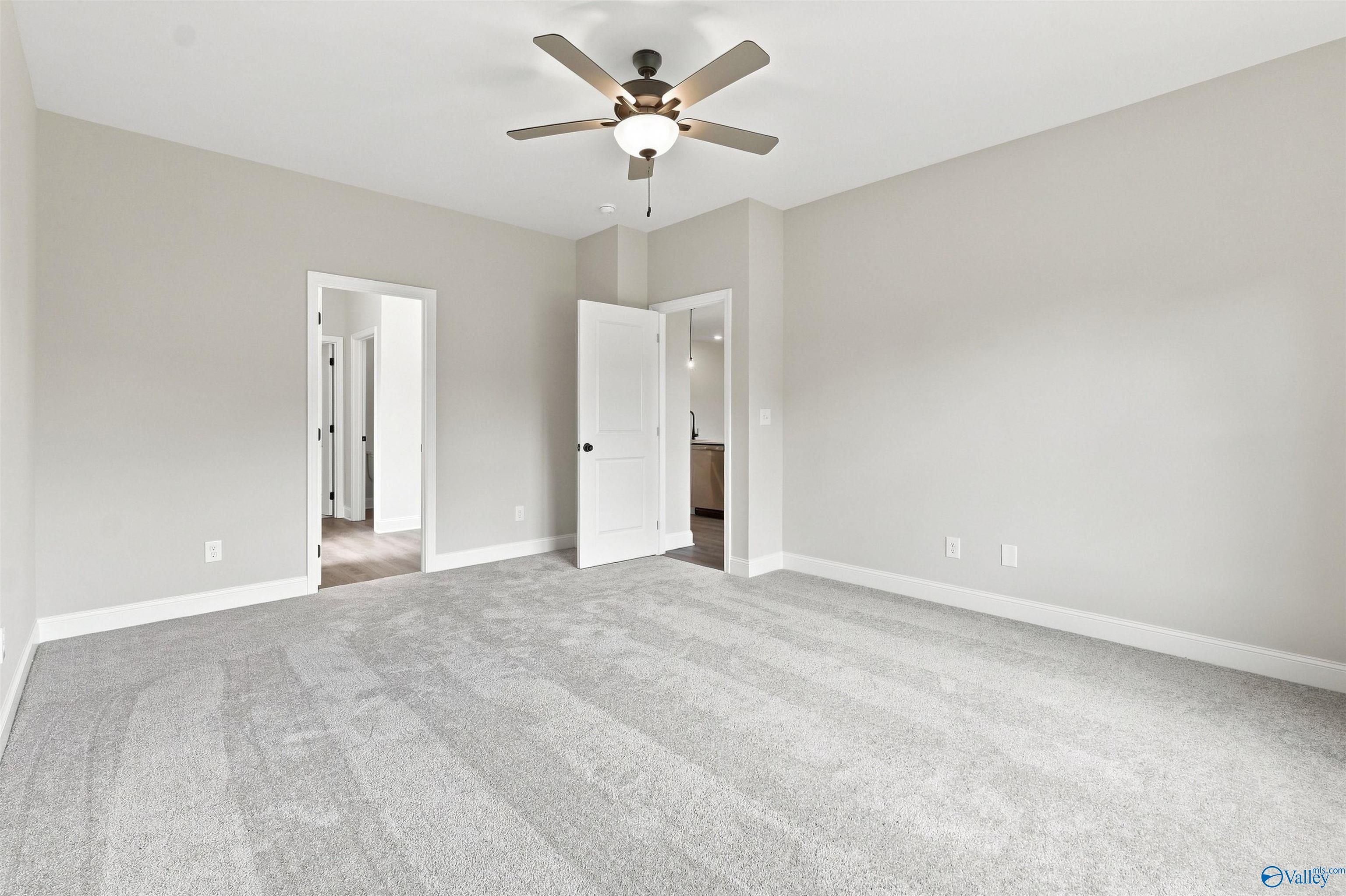 Spacious carpeted bedroom with ceiling fan in Davidson Homes The Everett B, 4-bedroom new home in Wood Trail, Toney, Alabama