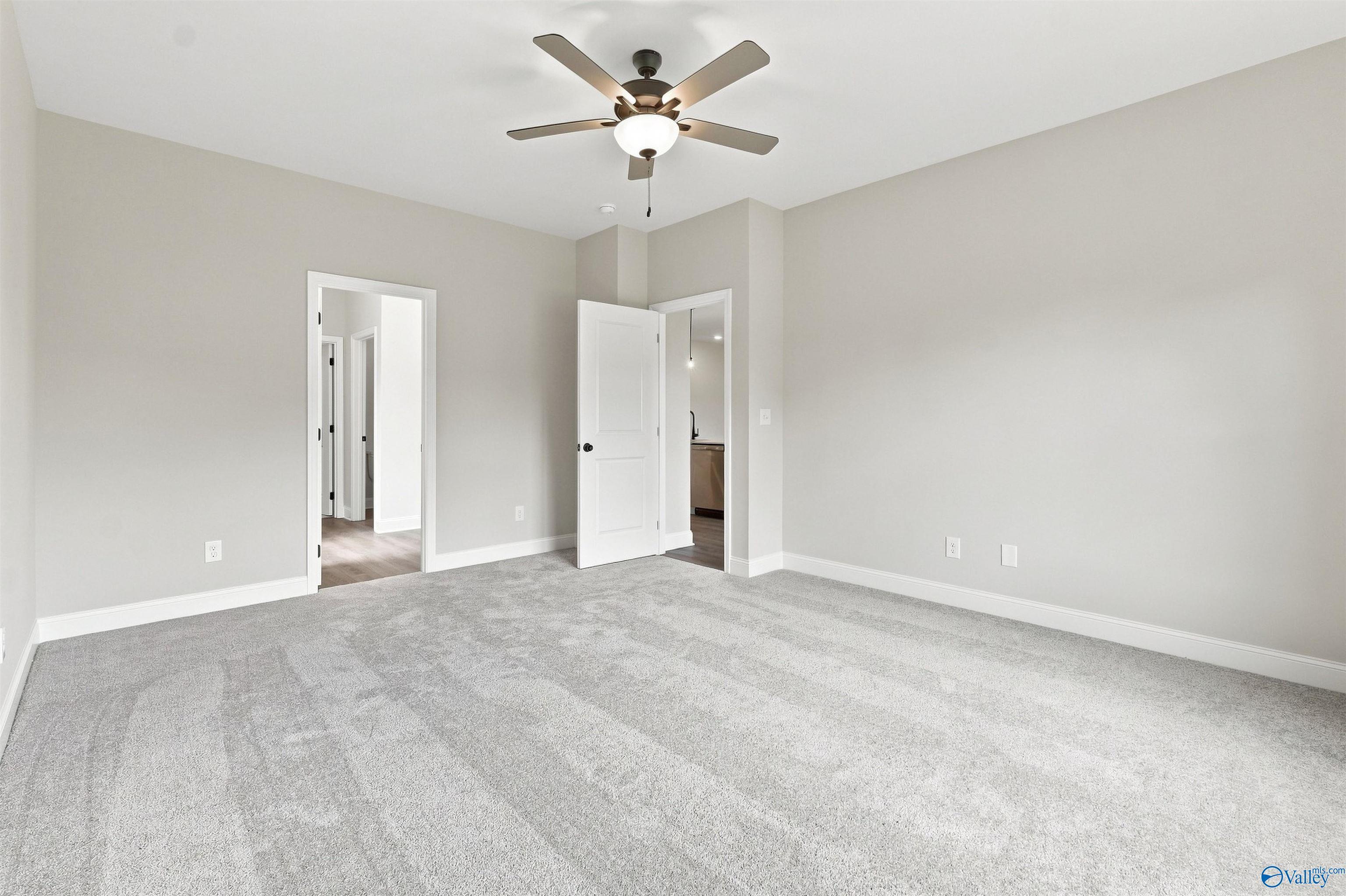 Spacious carpeted bedroom with ceiling fan in Davidson Homes The Everett B, 4-bedroom new home in Wood Trail, Toney, Alabama