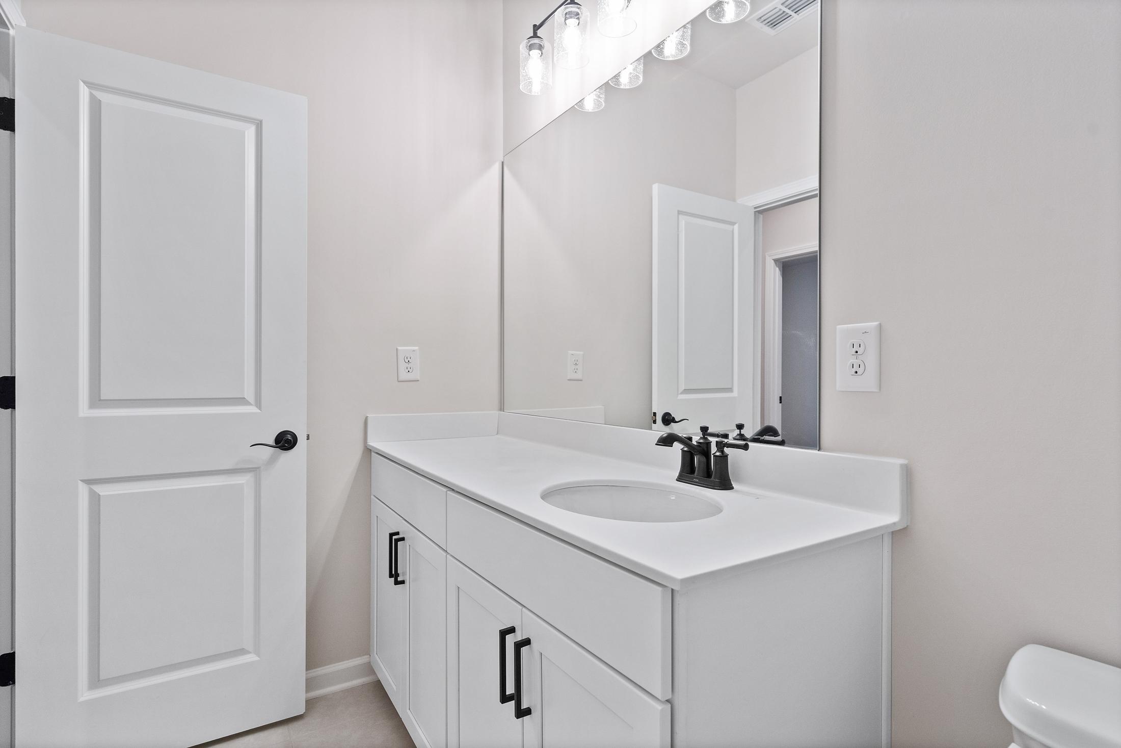 Modern master bathroom in The Glenwood with white shaker vanity, undermount sink, chrome faucet, and large mirror
