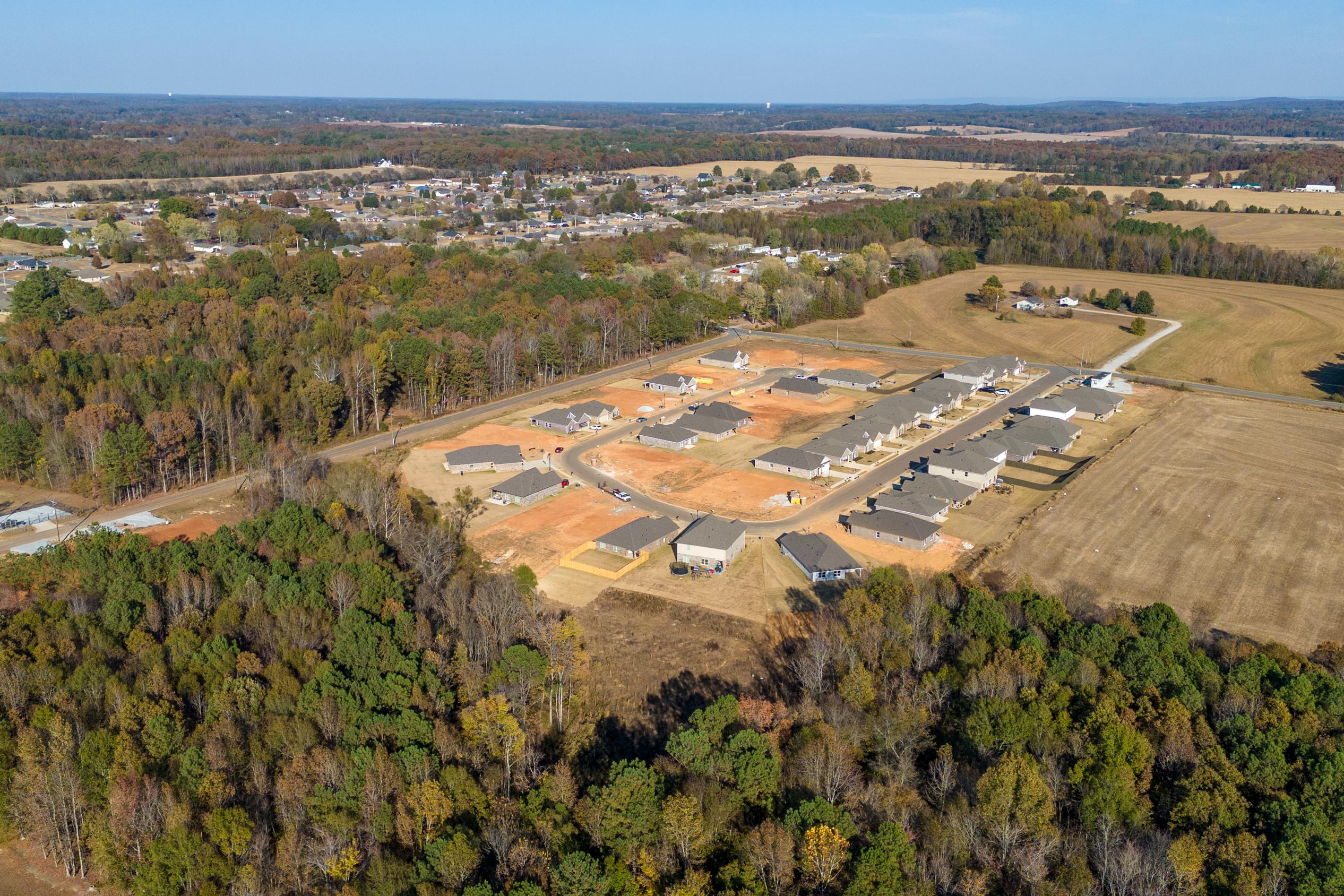 Aerial view of new home constructions at Mallard Landing in Athens Alabama surrounded by autumn woods and fields